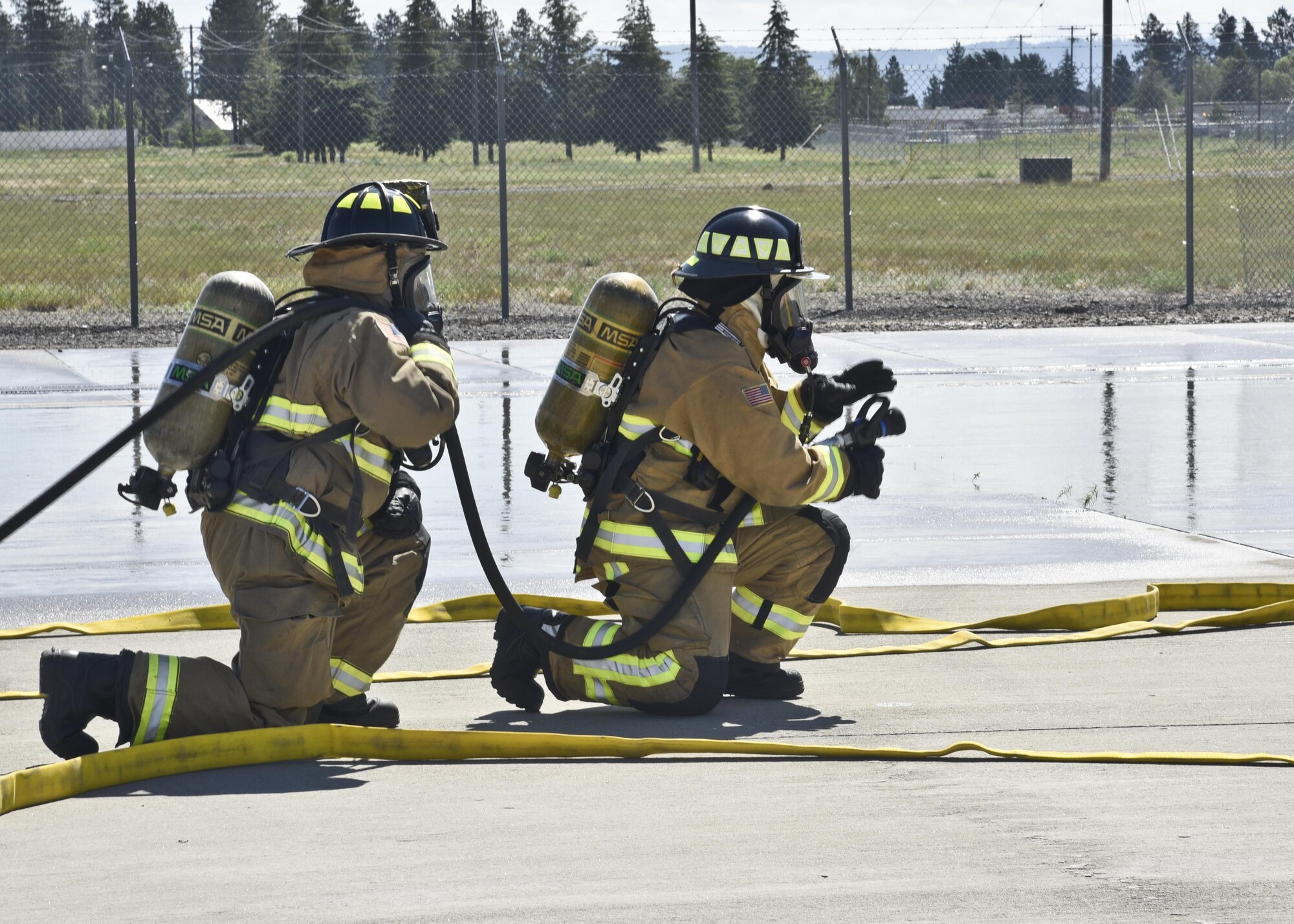 Staff Sgt. Michael Granados and Staff Sgt. Kari Dudoit, 92nd Civil Engineer Squadron firefighters, prepare to shoot water during an exercise with the Spokane International Airport June 9, 2016, in Spokane, Wash. The exercise included more than 40 local emergency responders from around the county to include: Spokane International Airport Fire and Rescue, Spokane International Airport Police Department, Spokane Fire Department, Fairchild Air Force Base Fire Department, Spokane County Fire District 10 and American Medical Response. (U.S. Air Force photo/Airman 1st Class Taylor Shelton)