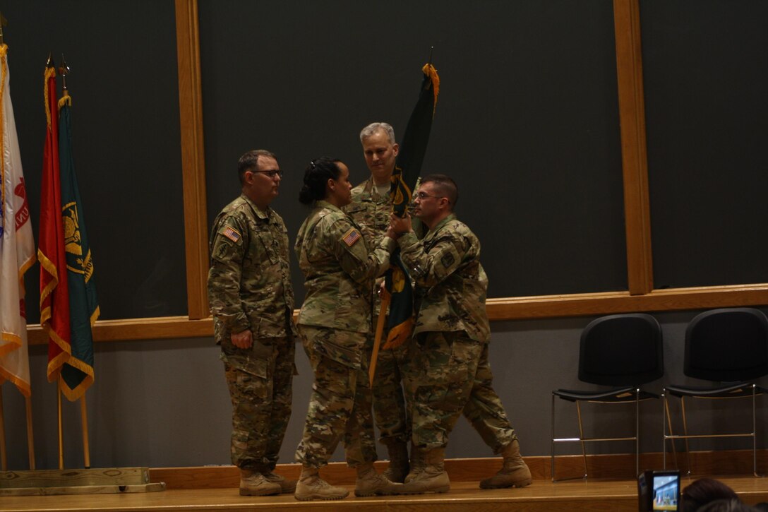 Lt. Col. Michael Napolitano, incoming SWCPC commander (right) receives the unit guidon from Master Sgt. Sonia Pierce (center), SWCPC senior NCO, as the ARCOG Commander, Col. Michael Smith (back) and SWCPC’s outgoing commander, Lt. Col. John Cadran (left), look on.  Napolitano took command of ARCOG’s South West Cyber Protection Center in San Antonio, Texas, April 16, 2016.  (Photo courtesy of Army Staff Sgt. Manuel Argumedo.)