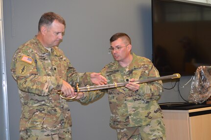 Lt. Col. Michael Napolitano (right), new SWCPC commander, presents a unit memento to Lt. Col. John Cadran (left), outgoing SWCPC commander. Napolitano took command of ARCOG’s South West Cyber Protection Center in San Antonio, Texas, April 16, 2016.  (Photo courtesy of Army Staff Sgt. Manuel Argumedo.)