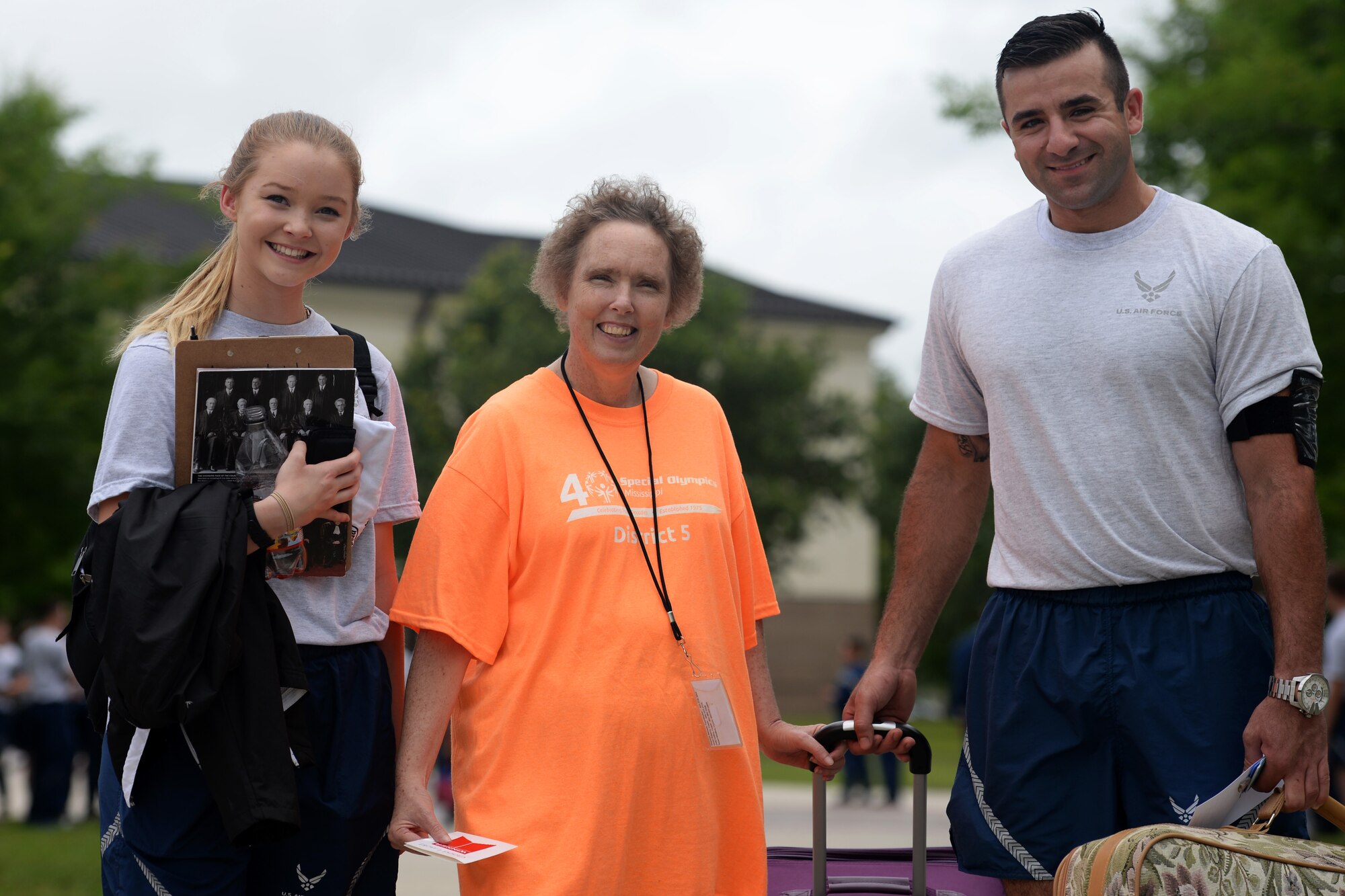 Airman Basic Ashlyn Tran and Senior Airman Hashim Mefleh, 336th Training Squadron students, help Paula Carpenter, District 5 Special Olympics Mississippi athlete, with her luggage May 20, 2016, Keesler Air Force Base, Miss. Carpenter has competed in SOMS for more than 25 years and this year Tran and Mefleh are her Airman sponsors. (U.S. Air Force photo by Airman 1st Class Travis Beihl)