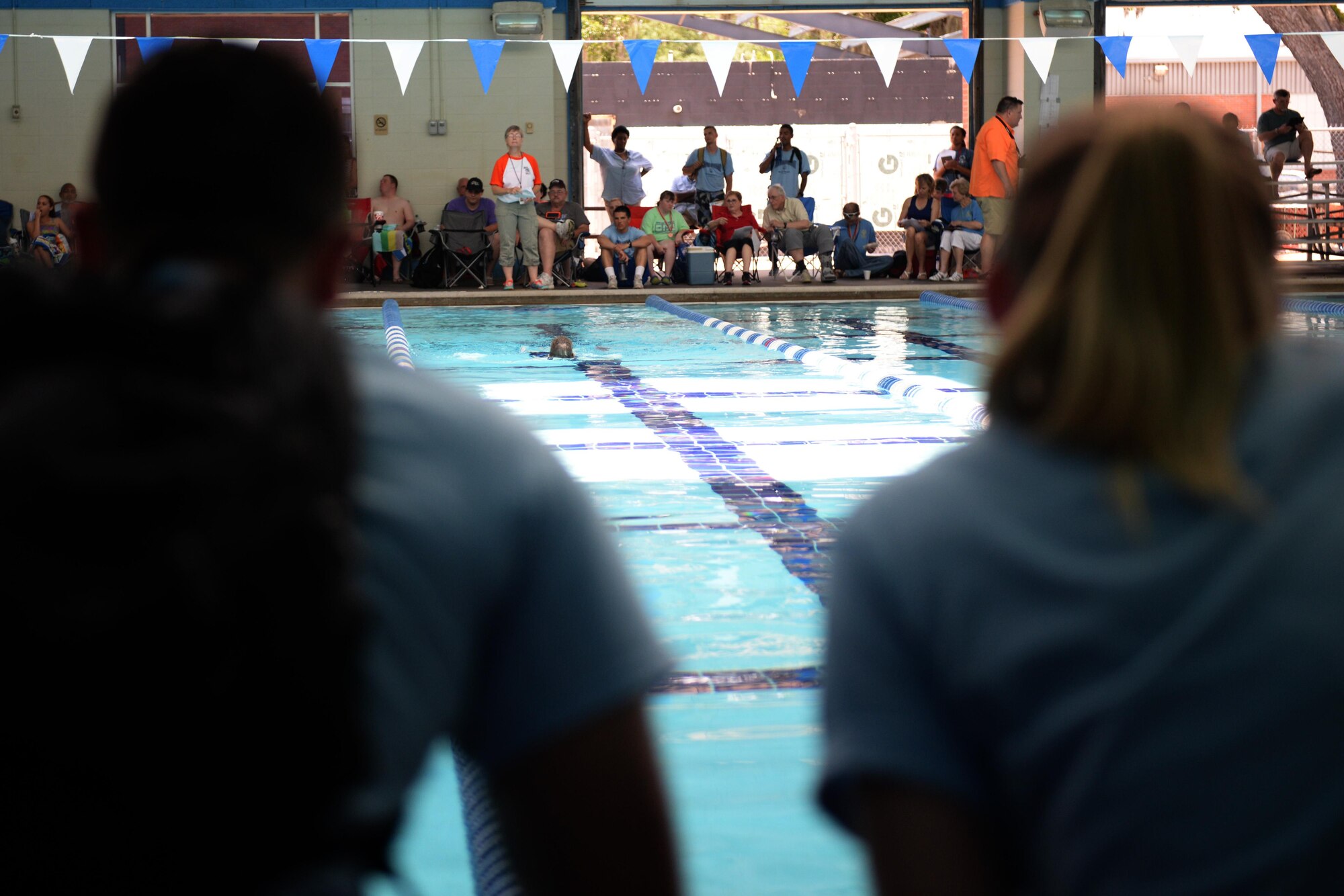 Senior Airman Hashim Mefleh and Airman Basic Ashlyn Tran, 336th Training Squadron students, cheer on Paula Carpenter, District 5 Special Olympics Mississippi athlete, as she competes in the 50 meter backstroke at the Biloxi Natatorium May 21, 2016, Biloxi, Miss. As Airman sponsors, Mefleh and Tran spent the weekend cheering on and getting to know Carpenter as she competed in the 50 meter backstroke, 25 meter freestyle relay and 50 meter freestyle. (U.S. Air Force photo by Airman 1st Class Travis Beihl) 