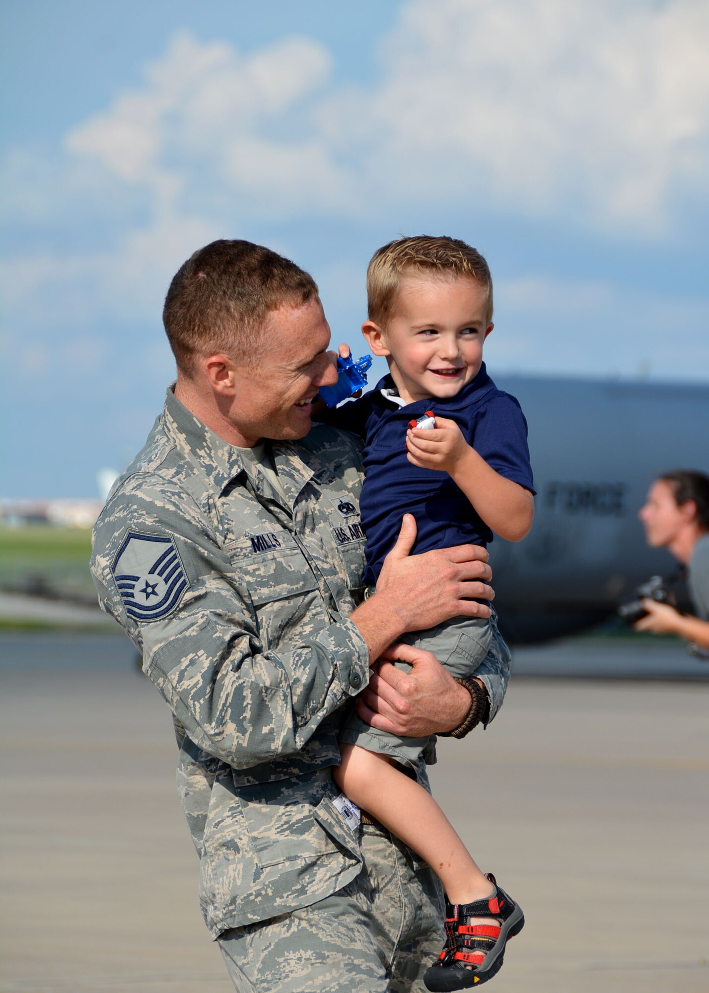 Master Sgt. Robert Mills of the 507th Maintenance Squadron at Tinker Air Force Base, Okla., holds his oldest son moments after returning from a four-month deployment from Southwest Asia June 11, 2016. Moments later, he met his two-month old son for the first time. (U.S. Air Force photo/Tech. Sgt. Lauren Gleason)