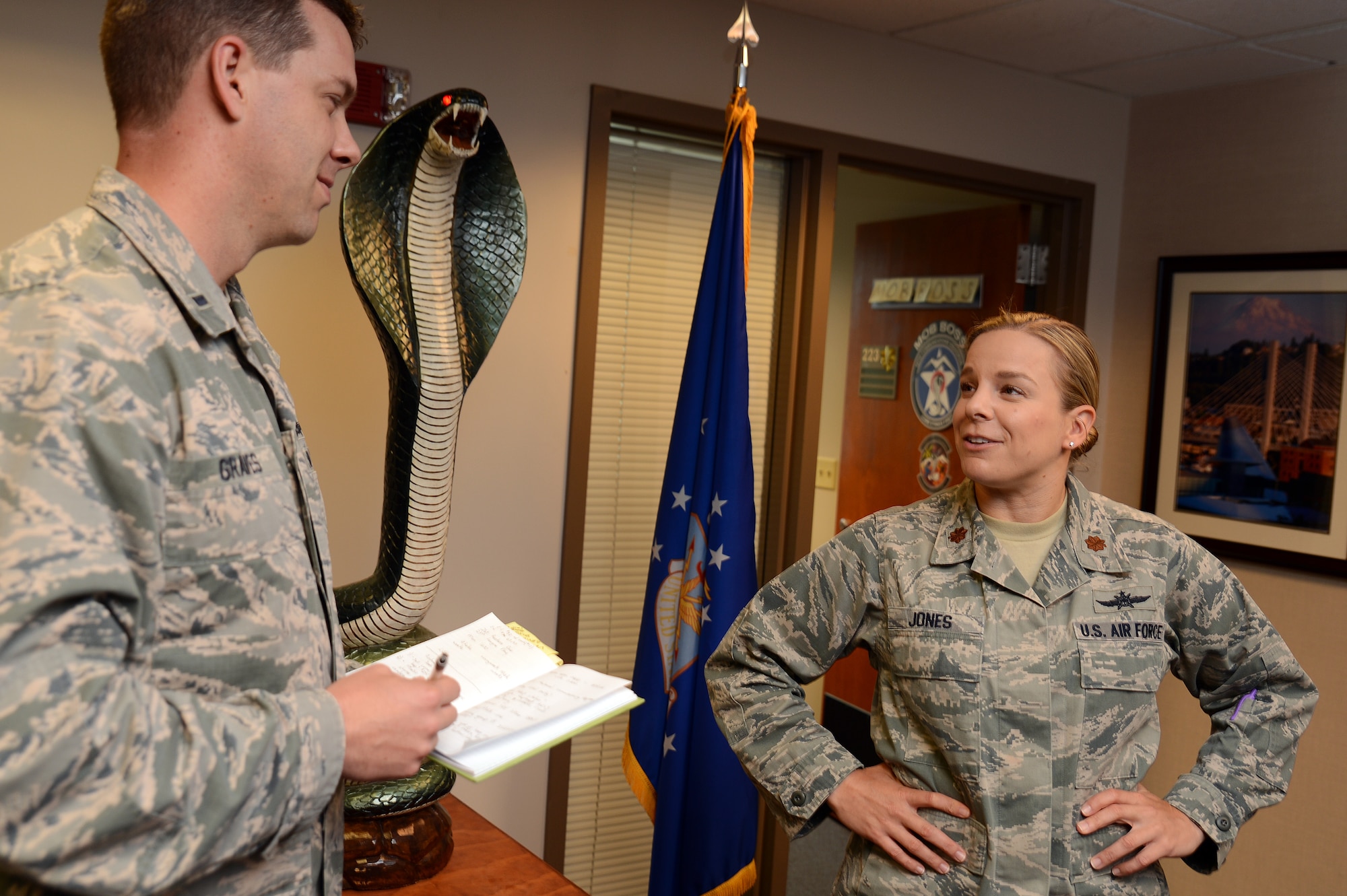 Maj. Jennifer Jones (right), 627th Communications Squadron director of operations, discusses work matters with 1st Lt. Bradley Graves, 627th CS client services and networks officer in charge June 9, 2016, at Joint Base Lewis-McChord, Wash. Jones oversees more than 100 Airmen and 10 sections for the 627th CS. (U.S. Air Force Photo/ Senior Airman Jacob Jimenez)  