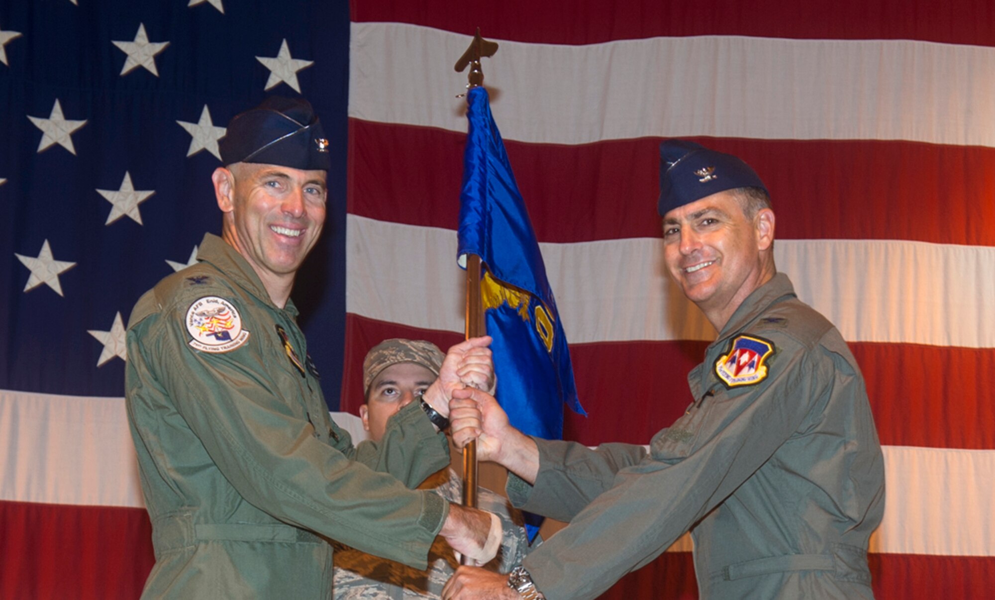 Col. Paul Johnson, right, the new commander of the 71st Operations Group, takes the 71st OG guidon from Col. Clark Quinn, the 71st Flying Training Wing commander, during the 71st OG change-of-command ceremony June 13 in Hangar 170 at Vance Air Force Base, Oklahoma. Johnson assumed command from Col. John Cinnamon who leaves Team Vance for the U.S. Air Force Academy in Colorado Springs, Colorado. (U.S. Air Force photo by Terry Wasson)