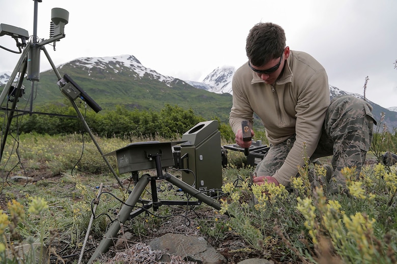 U.S. Air Force Senior Airman Christopher Eaton, assigned to the 3rd Operations Support Squadron, sets up a weather sensor at a base camp near Colony Glacier, Alaska, June 4, 2016. In November 1952, an Air Force C-124 Globemaster II crashed into nearby Mount Gannett in the Chugach Mountains killing all of the 52 people on board. Every summer since 2012, Alaskan Command and Alaska National Guard personnel support the joint effort of Operation Colony Glacier, a mission to recover human remains and remove debris. (U.S. Air Force photo/Alejandro Pena)  