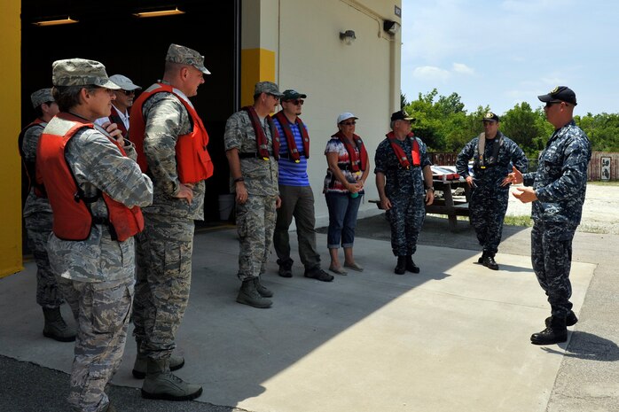 Petty Officer 1st Class Mark Vanwyck (right) briefs commanders and their Honorary Commanders prior to a tour of the Cooper River at Joint Base Charleston, S.C., June 13, 2016. The tour allowed leaders to learn about the unique water mission the Navy shares with the Air Force and see first-hand what it is like to patrol the harbor. (U.S. Air Force photo/Tech. Sgt. Renae Pittman)