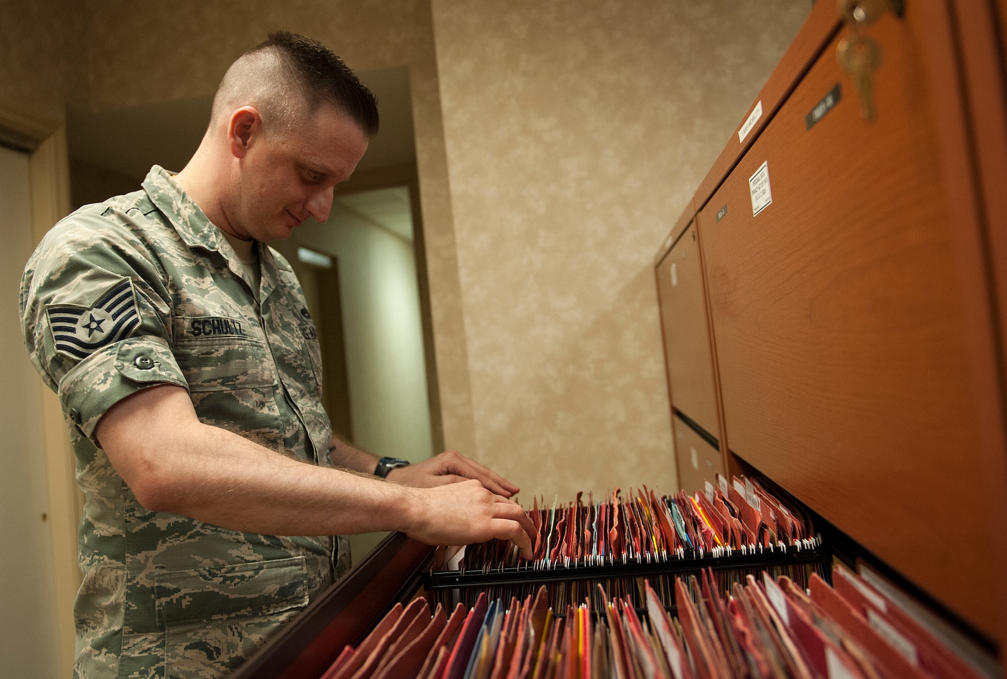 U.S. Air Force Tech. Sgt. Arron Schultz, 1st Maintenance Squadron unit deployment manager, searches through deployment files at Langley Air Force Base, Va., June 9, 2016. As a UDM, Schultz is responsible for ensuring that each Airman in his unit is prepared for their deployment. (U.S. Air Force photo by Airman 1st Class Kaylee Dubois)