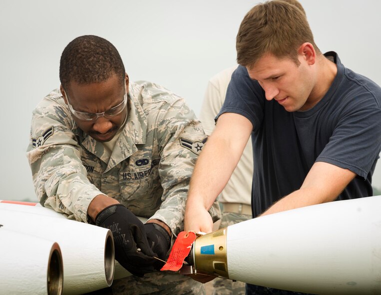 U.S. Airman 1st Class Eric Ligon, 5th Expeditionary Munitions Squadron crew chief, and Petty Officer 2nd Class Ray Charles Newman, Navy Munitions Command Unit Charleston mineman, cut arming wire to a MK-62 Quick Strike inert mine at Royal Air Force Fairford, United Kingdom, June 8, 2016. Navy minemen built 12 inert mines for a BALTOPS 16 exercise testing the B-52H Stratofortress’ ability to precisely drop munitions into a target zone. (U.S. Air Force photo/Senior Airman Sahara L. Fales)