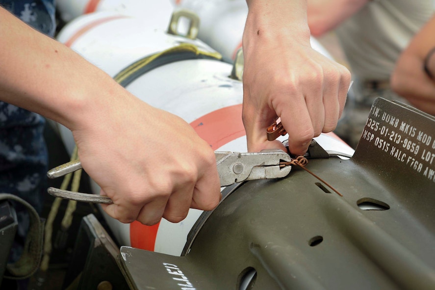 U.S. Seaman Clarence Burns, Navy Munitions Command Unit Charleston mineman, attaches an arming wire to an inert mine at Royal Air Force Fairford, United Kingdom, June 8, 2016. The inert mine was loaded onto a B-52H Stratofortress forward deployed to RAF Fairford to participate in multi-national exercises, train with the United States’ allies and partners and showcase the aircraft’s capabilities. (U.S. Air Force photo/Senior Airman Sahara L. Fales)