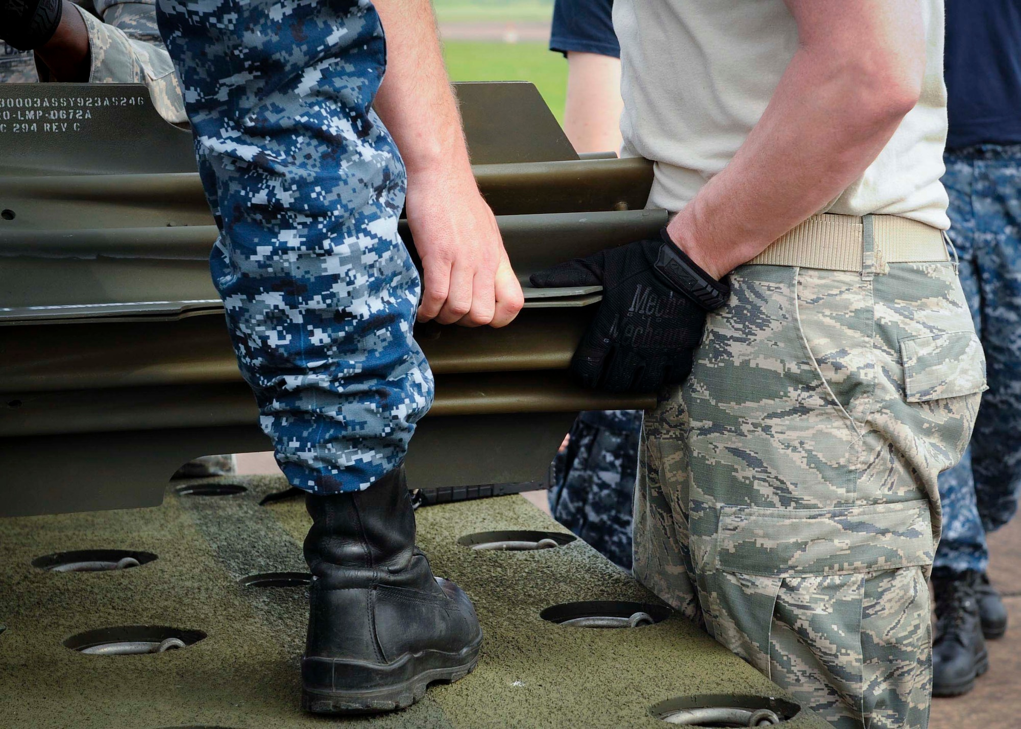 A U.S. Navy mineman and U.S. Air Force munitions Airman attach a MK-15 tailfin to an inert mine at Royal Air Force Fairford, United Kingdom, June 8, 2016. The mines were built in support of exercise BALTOPS 16 which provides an opportunity for personnel from different services and nations to engage in realistic maritime training to build experience and teamwork and strengthen interoperability. (U.S. Air Force photo/Senior Airman Sahara L. Fales)