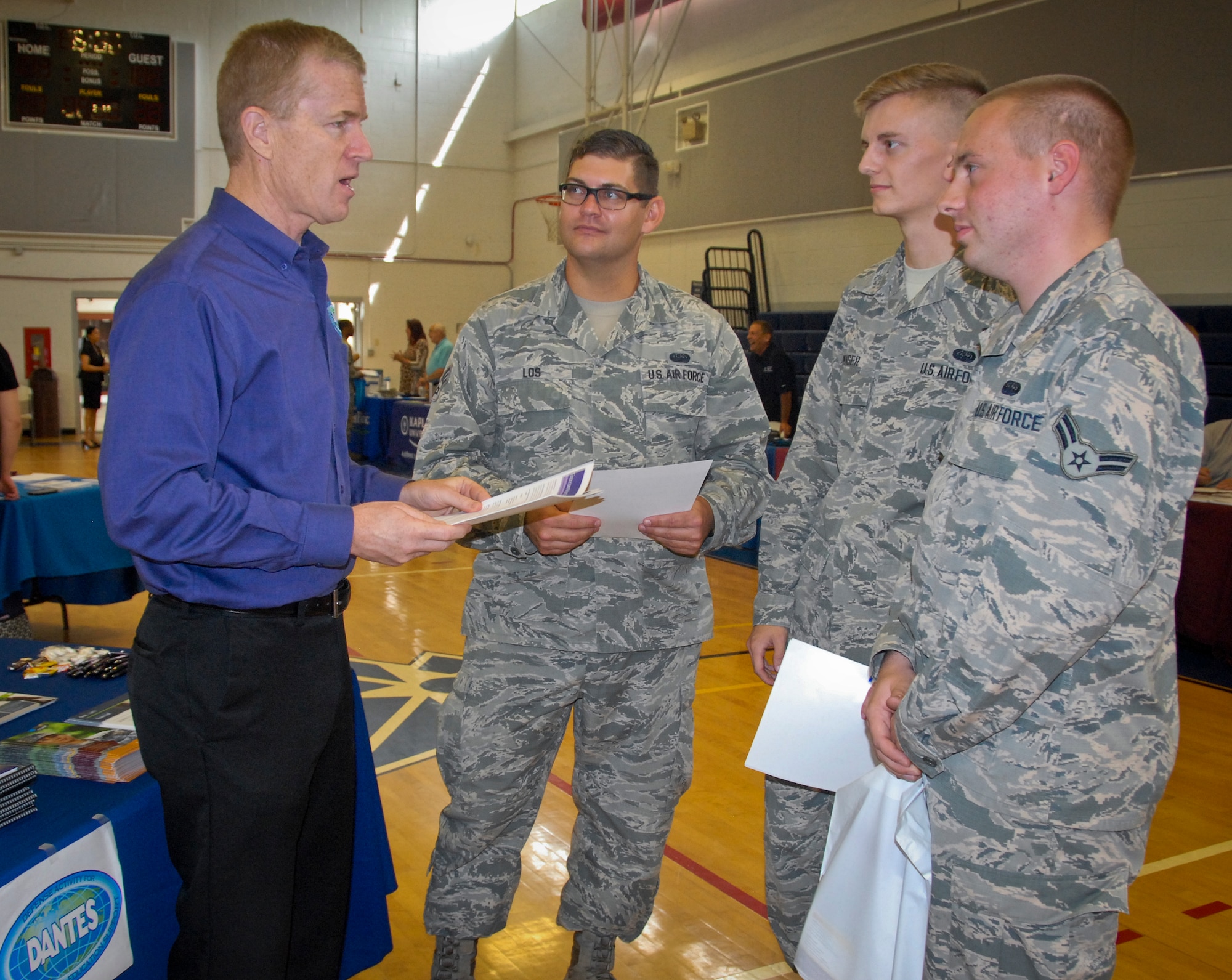 Mike Stahl, deputy director for the Defense Activity for Non-Traditional Education Support program, talks to Senior Airman Randall Los and Airmen 1st Class Edward Menser and Joshua Lezu, from the 96th Communications Squadron, about what DANTES offers at the Education Fair June 8 at Eglin Air Force Base, Fla.  (U.S. Air Force photo/Kevin Gaddie)