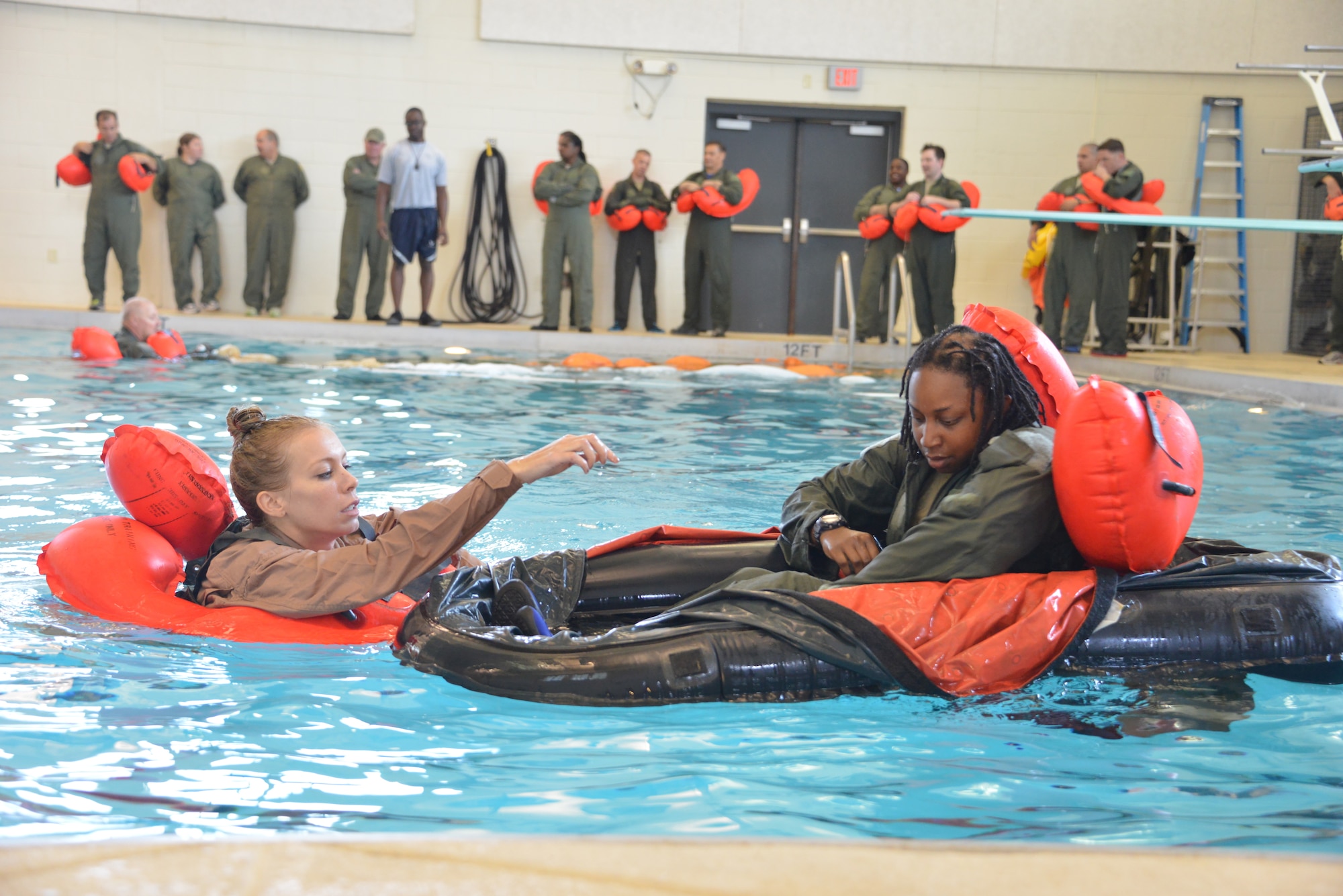 Staff Sgt. Rainey Cannady assists Master Sgt. Brandi Bolden on the proper use of a
 one-person life raft during annual water survivor training. Crew members of the 165th Airlift Wing Savannah, Ga. recertified in water survivor training as part of the aircrew requirements. The training was held at Hunter Army Airfield, indoor swimming facilities, Savannah, Ga. (U.S. Air National Guard Photo by Staff Sargent Noel Velez/Released) 