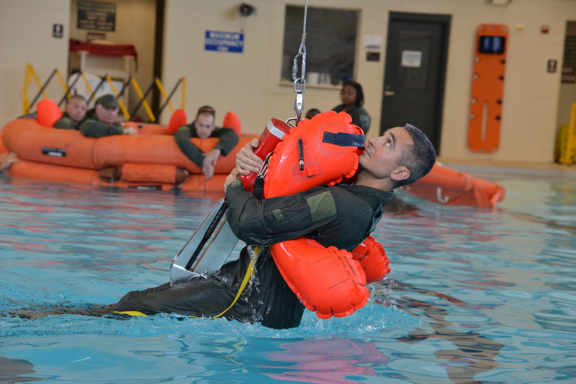 Master Sgt. Jorge Chavez demonstrates proper water extraction during water survival training. Crew members of the 165th Airlift Wing Savannah, Ga. recertified in water survivor training as part of the aircrew requirements. The training was held at Hunter Army Airfield, indoor swimming pool facilities, Savannah, Ga. (U.S. Air National Guard Photo by Staff Sargent Noel Velez/Released) 