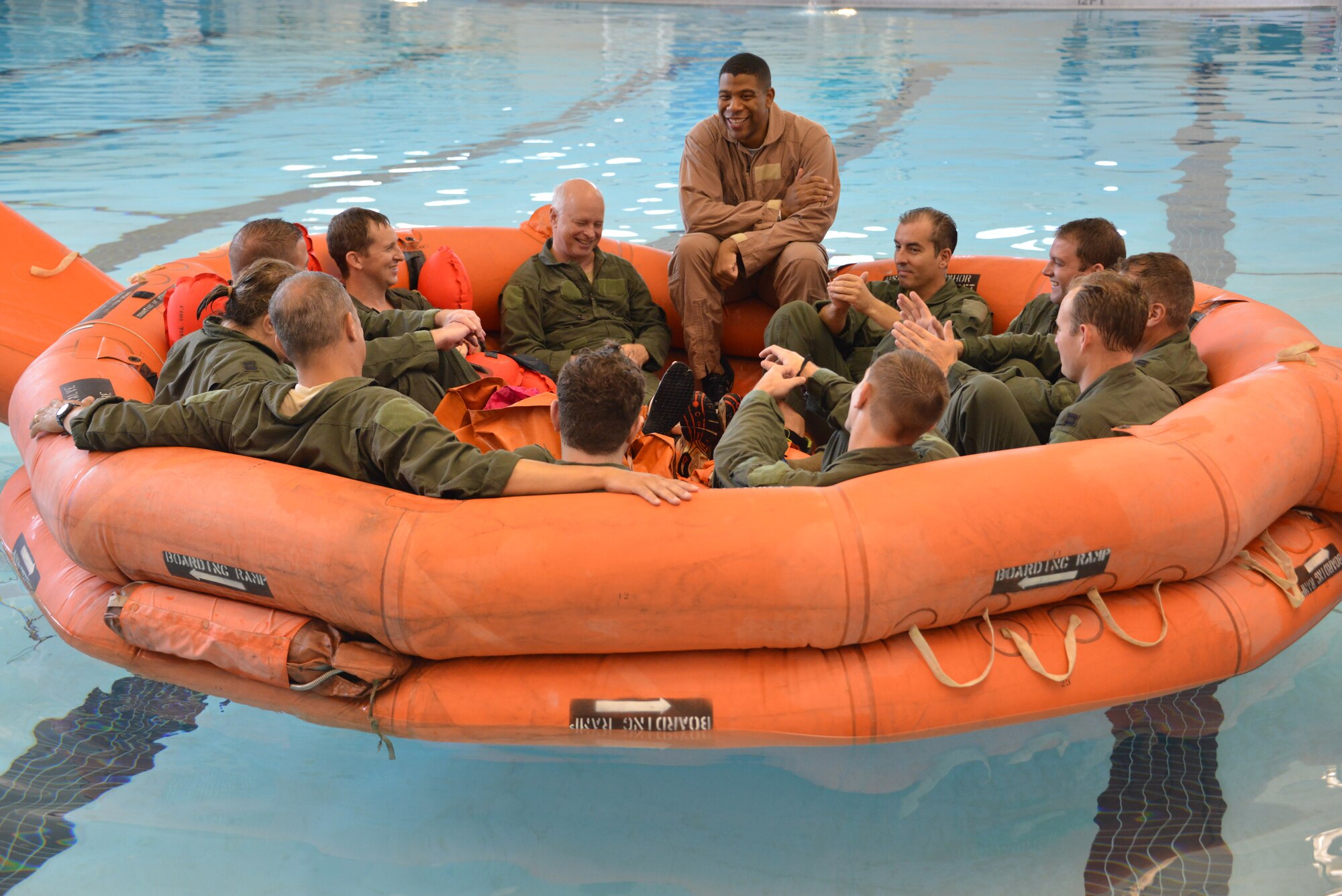 Staff Sgt. Adam Best demonstrates the proper use of a 20-person life raft to aircrew members during annual water survivor training. Crew members of the 165th Airlift Wing Savannah, Ga. recertified in water survivor training as part of the aircrew requirements. The training was held at Hunter Army Airfield, indoor swimming pool facilities, Savannah, Ga. (U.S. Air National Guard Photo by Staff Sargent Noel Velez/Released) 