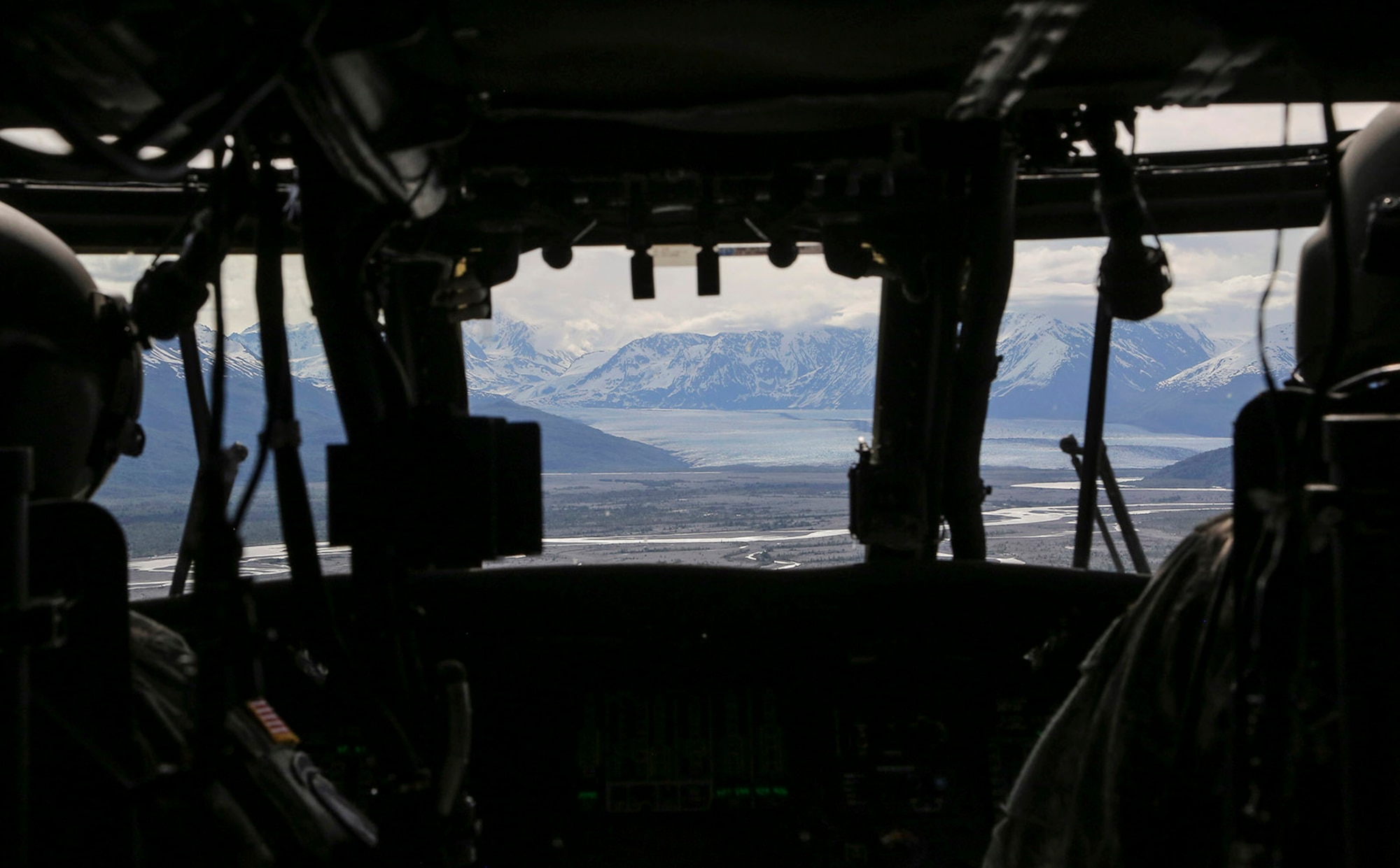 Alaska Army National Guard UH-60 Black Hawk helicopter pilots, Chief Warrant Officer 3 David Friend, left, and Maj. Todd Miller, assigned to the 1st Battalion, 207th Aviation Regiment, approach the Chugach Mountains while conducting flight operations during Operation Colony Glacier in Alaska, June 4, 2016. In November 1952, a U.S. Air Force C-124 Globemaster II crashed into Mt. Gannett in the Chugach Mountains near Anchorage killing all of the 52 servicemembers on board. Every summer since 2012, Alaskan Command, the Alaska National Guard, Air Force Mortuary Affairs Operations, U.S. Army Alaska, 673d Air Base Wing, 3d Wing and Detachment 1, 66 Training Squadron personnel support the joint effort of Operation Colony Glacier, a mission to recover any human remains and remove debris. (U.S. Air Force photo/Alejandro Pena)