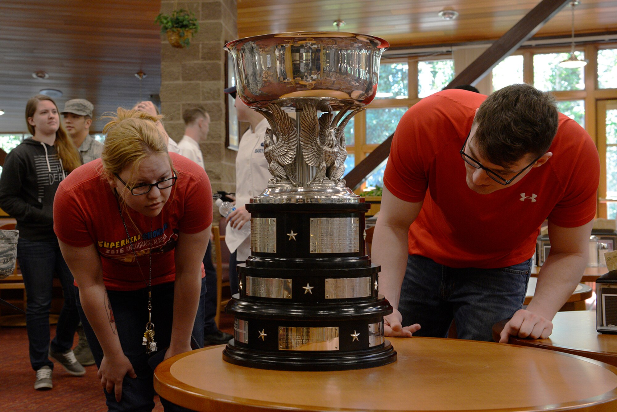Airman 1st Class Alexandria Tyner, left, and Senior Airman Dillon Brush, right, take a closer look at the 2016 John L. Hennessy Award presented to the Iditarod Dining Facility at Joint Base Elmendorf-Richardson, Alaska, June 8, 2016. Tyner and Brush are both assigned to the 673d Force Support Squadron. (U.S. Air Force photo by Airman 1st Class Valerie Monroy)