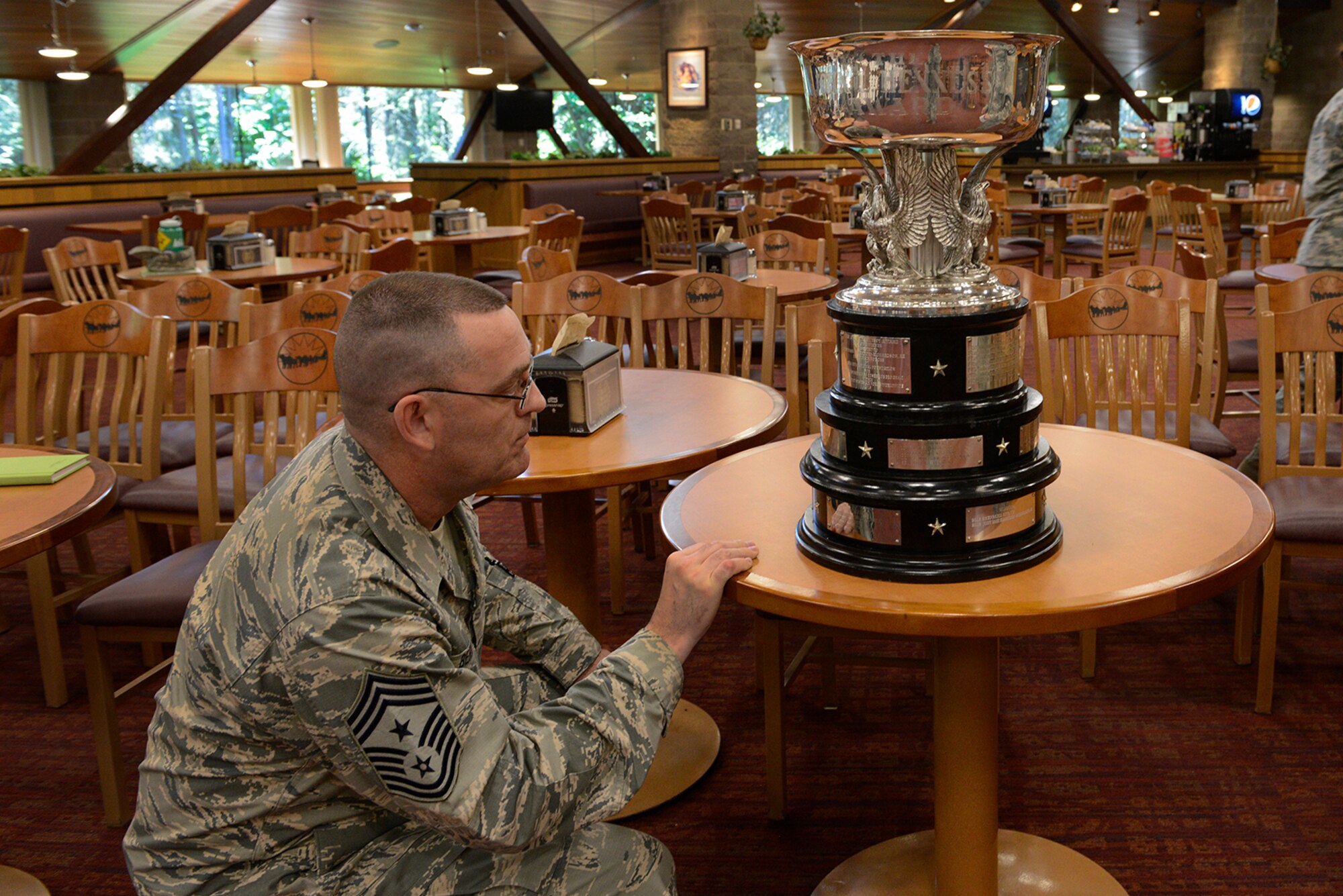 Chief Master Sgt. Garry Berry, Joint Base Elmendorf-Richardson and 673 Air Base Wing command chief, examines the 2016 John L. Hennessy Award presented to the Iditarod Dining Facility at Joint Base Elmendorf-Richardson, Alaska, June 8, 2016. The Hennessy travelers who decide the winners evaluate 5 things: kitchen operations, serving and dining operations, training personnel and readiness, sanitation and repair maintenance, and management.  (U.S. Air Force photo by Airman 1st Class Valerie Monroy)