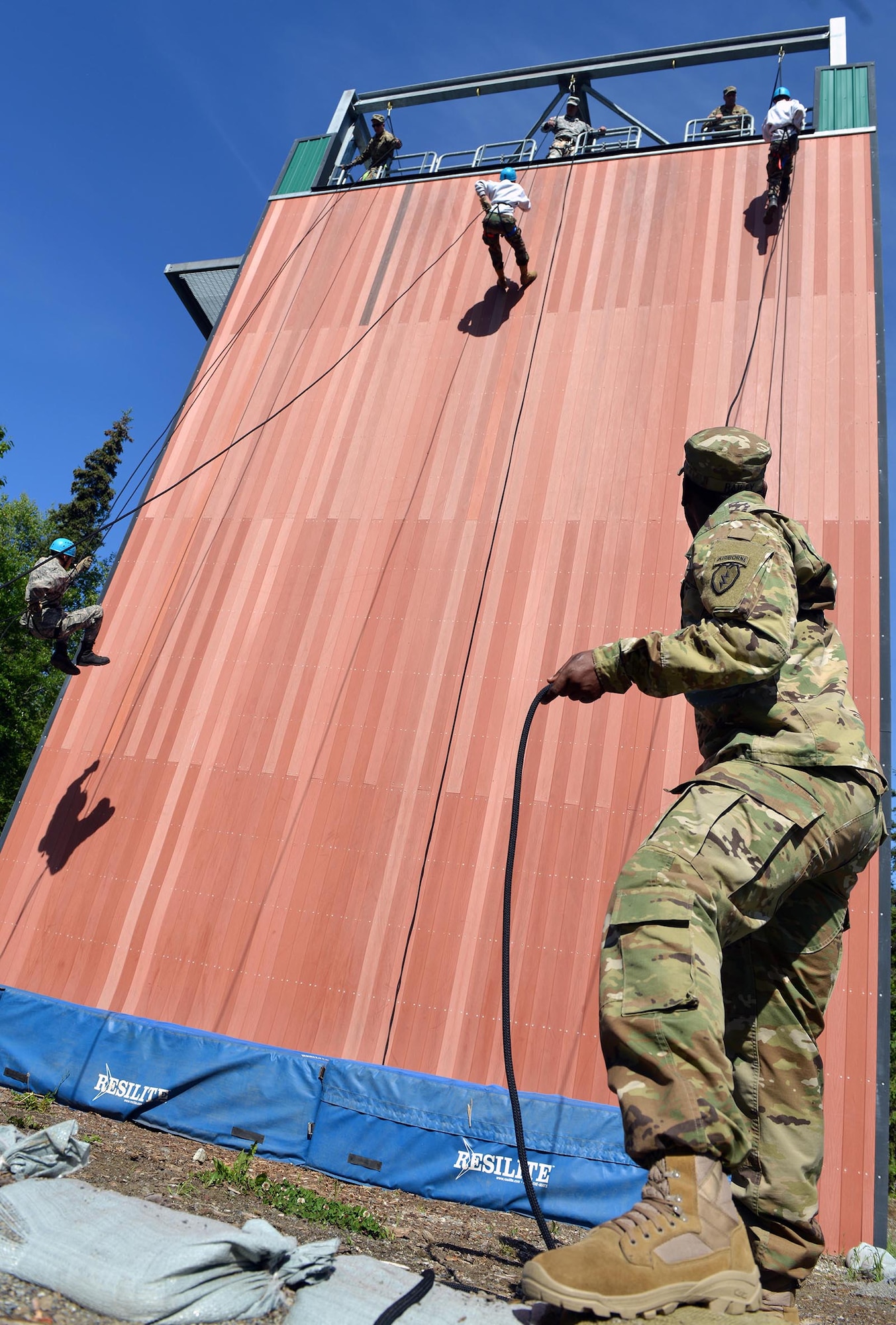 Army Sgt. Timothy Biley, a squad leader with 1st Battalion, 501st Parachute Infantry Regiment, 4th Infantry Brigade Combat Team (Airborne), 25th Infantry Division, belays a rappeller as Alaska School District Junior ROTC cadets rappel on Joint Base Elmendorf-Richardson, Alaska, June 9, 2016. Ten Alaska high schools participated in the Junior ROTC Summer Leadership Camp at Joint Base Elmendorf-Richardson, Alaska, from May 23 to June 10, 2016. (U.S. Air Force photo by Airman 1st Class Javier Alvarez)
