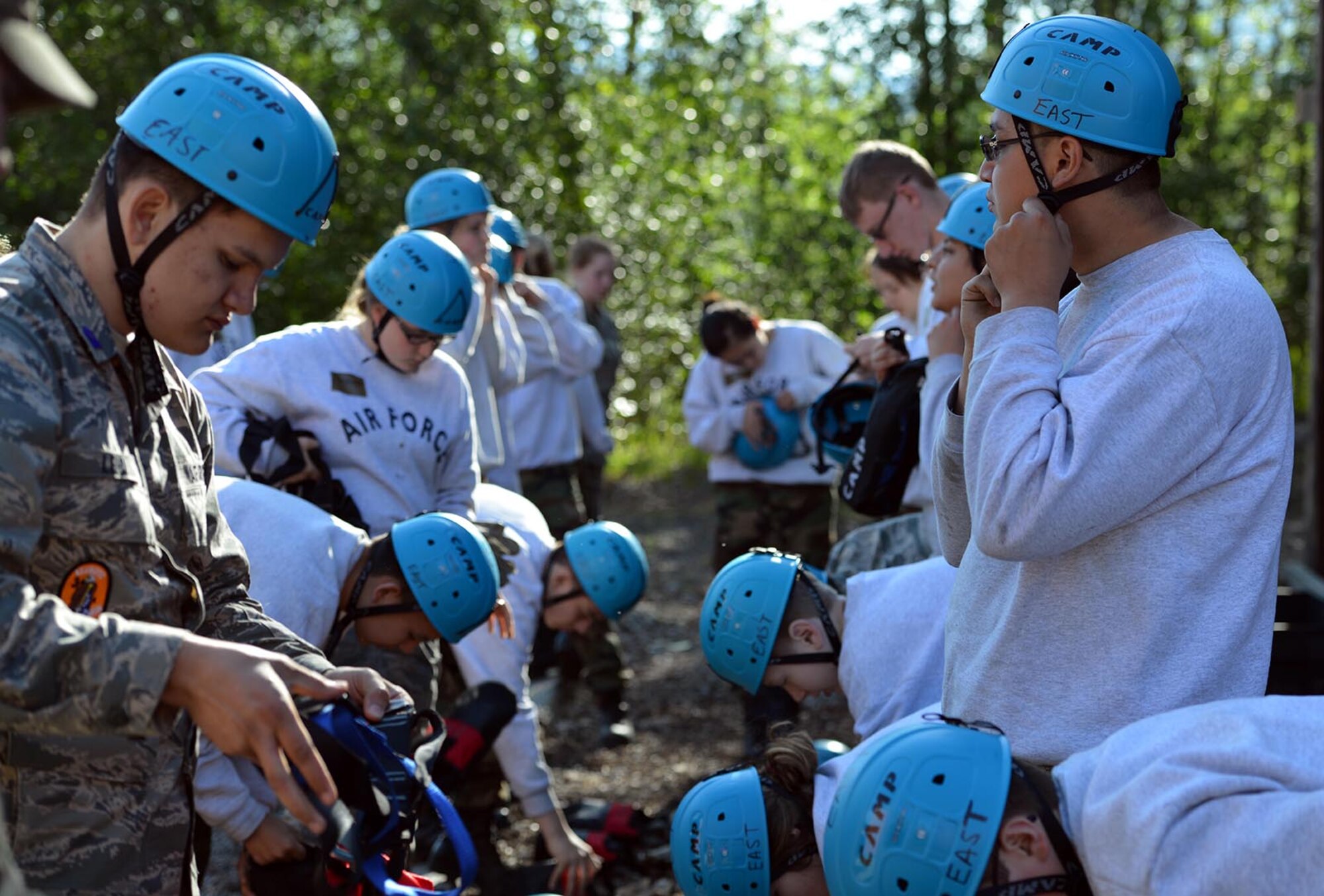Junior ROTC cadets fasten their helmets and gear as they prepare to go down the rappel tower as part of Summer Leadership Camp on Joint Base Elmendorf-Richardson, Alaska, June 9, 2016. Accountability, courtesies, professionalism, courage, and morale and welfare were among the topics covered at the camp. (U.S. Air Force photo by Airman 1st Class Javier Alvarez)