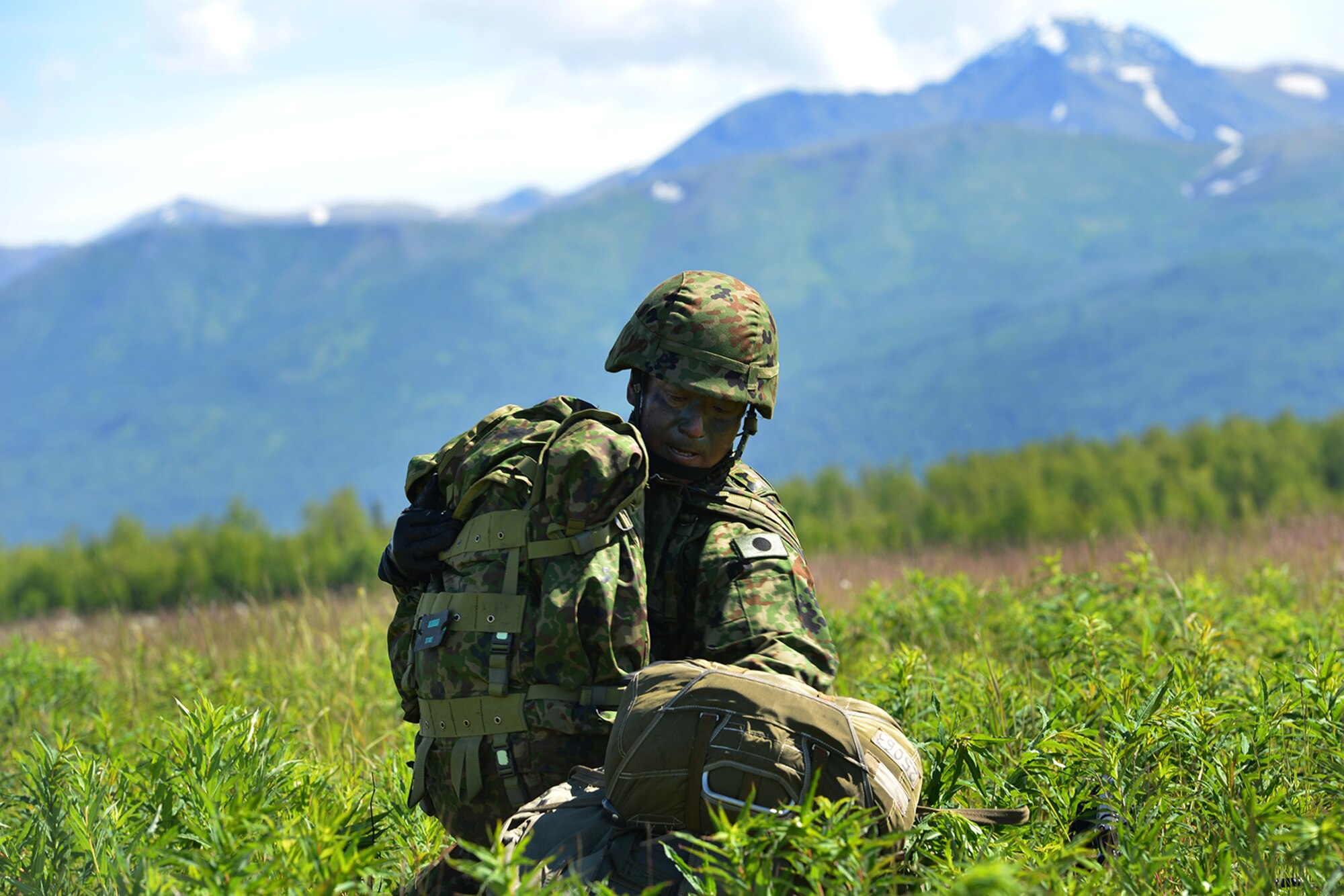 Paratroopers assigned to the 4th Infantry Brigade Combat Team (Airborne), 25th Infantry Division, U.S. Army Alaska, and the Japan Ground Self-Defense Force execute an airborne proficiency operation, and coordination for follow-on training at Joint Base Elmendorf-Richardson, Alaska, June 9, 2016, during Exercise Arctic Aurora. Arctic Aurora is a yearly bilateral training exercise involving elements of the Spartan Brigade and the JGSDF, which focuses on strengthening ties between the two by executing combined small unit airborne proficiency operations and basic small arms marksmanship. (U.S. Air Force photo by Airman 1st Class Valerie Monroy)