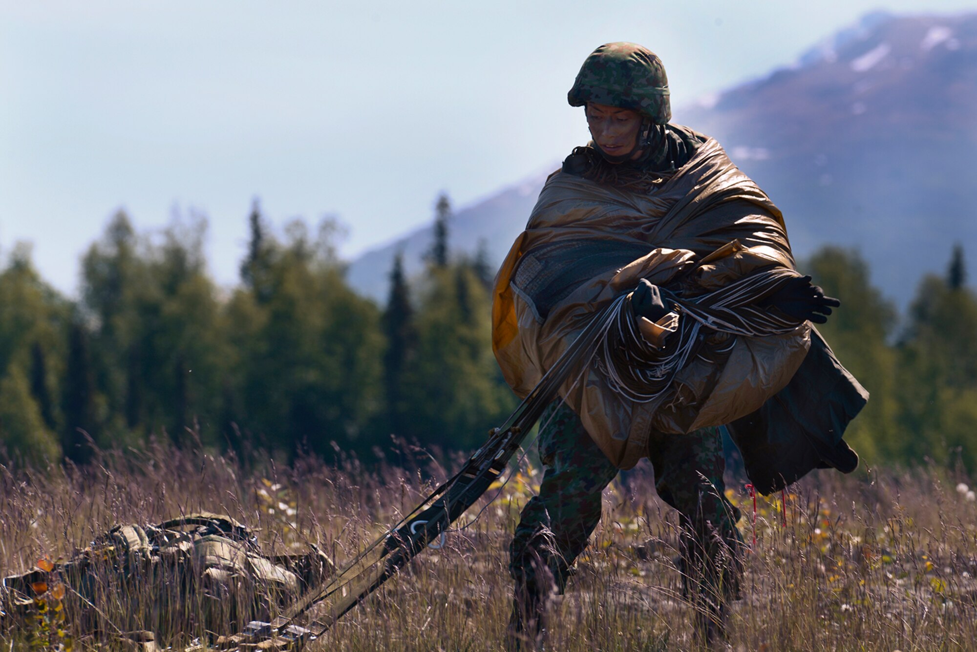 Paratroopers assigned to the 4th Infantry Brigade Combat Team (Airborne), 25th Infantry Division, U.S. Army Alaska, and the Japan Ground Self-Defense Force execute an airborne proficiency operation, and coordination for follow-on training at Joint Base Elmendorf-Richardson, Alaska, June 9, 2016, during Exercise Arctic Aurora. Arctic Aurora is a yearly bilateral training exercise involving elements of the Spartan Brigade and the JGSDF, which focuses on strengthening ties between the two by executing combined small unit airborne proficiency operations and basic small arms marksmanship. (U.S. Air Force photo by Airman 1st Class Valerie Monroy)