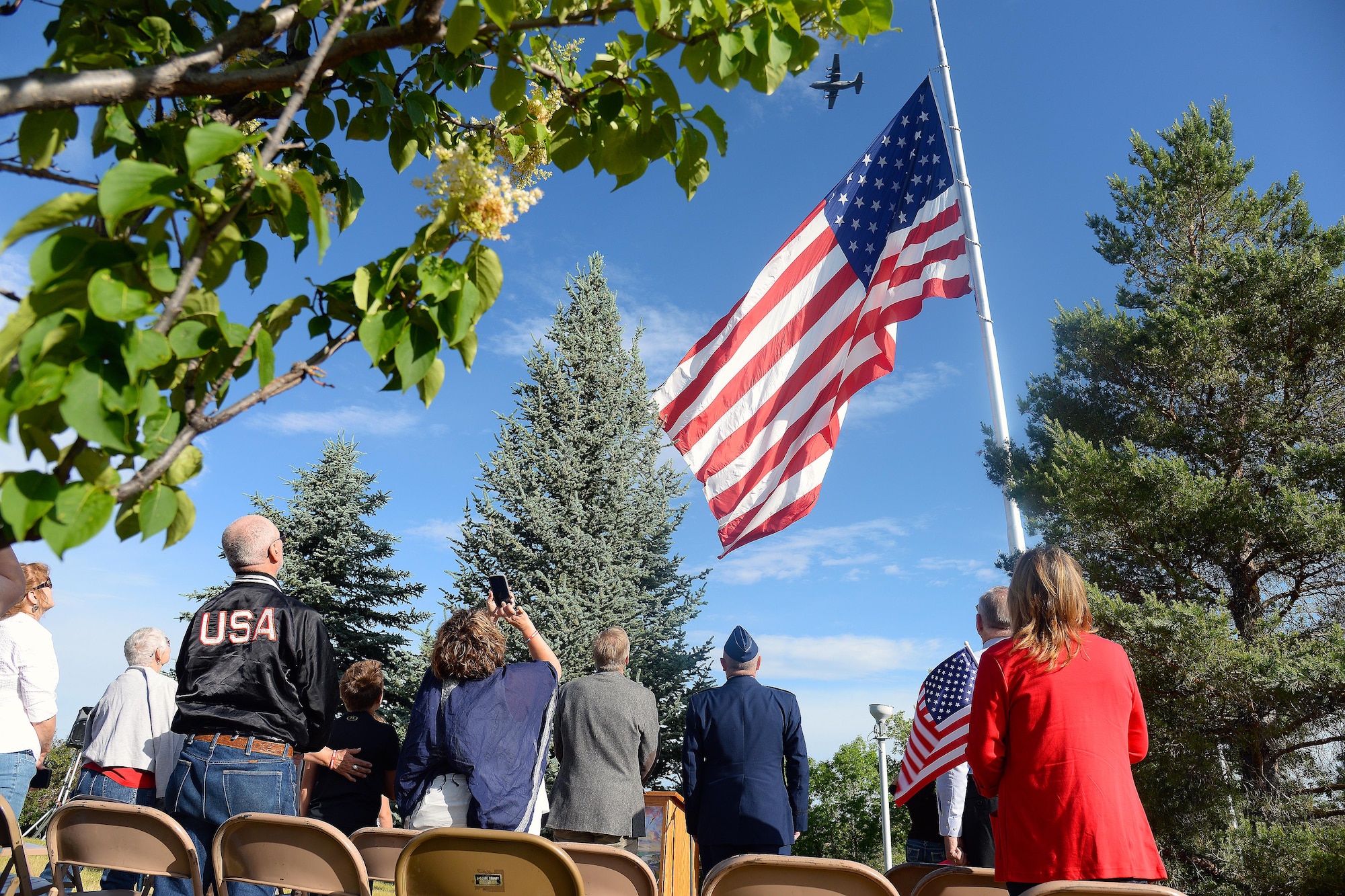 Community members from Great Falls, Mont., watch as the American flag is raised and Airmen assigned to the 120th Airlift Wing complete a flyover June 14, 2016, at Overlook Park. The event was held in celebration of Flag Day. (U.S. Air Force photo/Airman 1st Class Magen M. Reeves) 