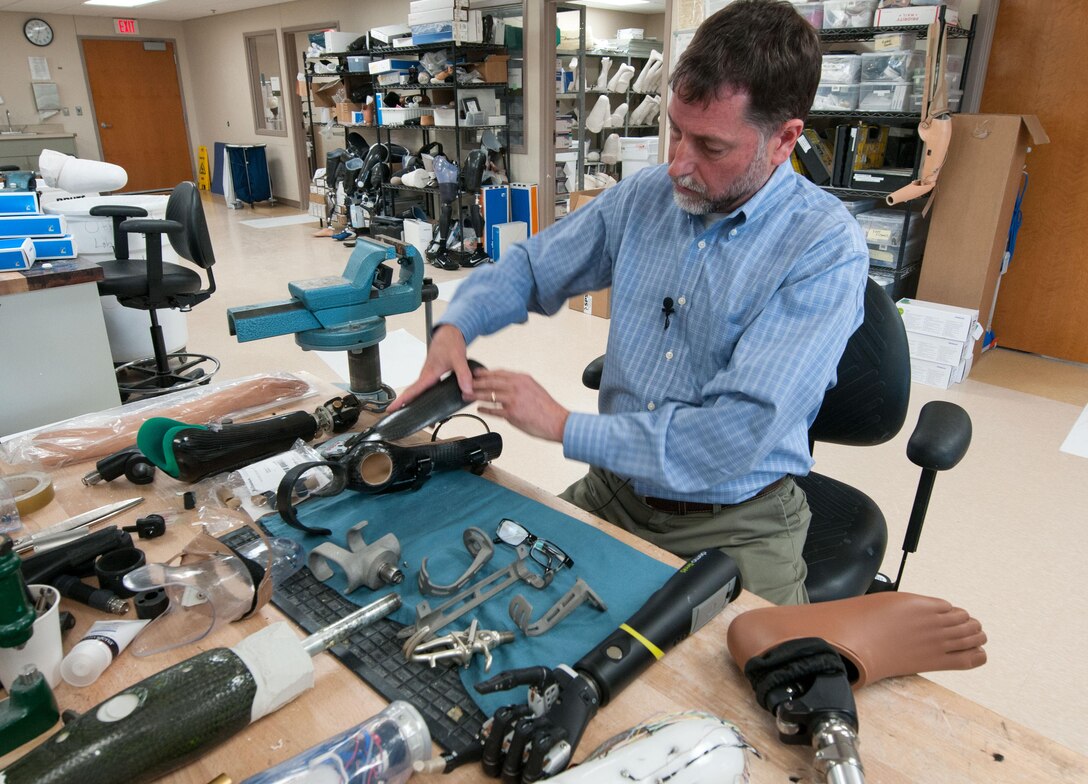 David Beachler, a prosthetist, works at his desk inside the prosthetics fabrication room at Walter Reed National Military Medical Center in Bethesda, Md., April 13, 2016. Amputees are consulted before prosthetists design their customized lightweight prosthetics, which weigh less than the actual limb lost. Many of the devices are made or modified in-house. (U.S. Air Force photo/Sean Kimmons)