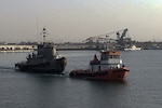 A contract tug begins its 12-hour journey from Kuwait Naval Base to the port of Doha, Qatar, with the retired Army tugboat in tow.