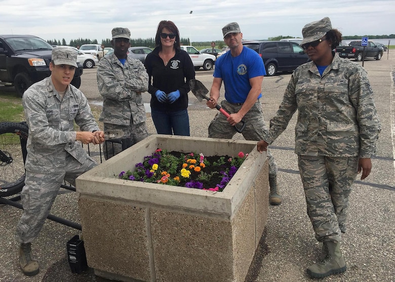 Airmen from the 10th Space Warning Squadron plant flowers in recognition of Arbor Day on June 3, 2016 at Cavalier Air Force Station, N.D. The day’s events consisted of the Tree City U.S.A. presentation, flower and tree planning, a site picnic and the ceremonial first watering. (Courtesy photo)