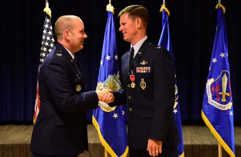 Col. Doug Schiess, 21st Space Wing commander, congratulates Col. Richard Burchfield, 21st SW Senior Individual Mobilization Augmentee, during Burchfield’s retirement ceremony at Peterson Air Force Base, Colo., June 10, 2016. Burchfield served in the Air Force for nearly 30 years between his time in active duty and the Reserves. (U.S. Air Force photo by Staff Sgt. Amber Grimm)