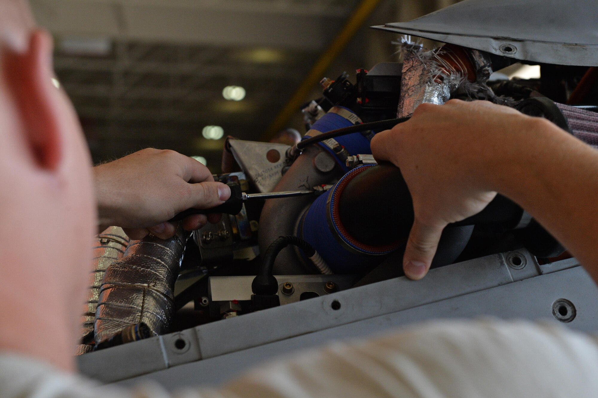 A 432nd Aircraft Maintenance Squadron crew chief fastens a bolt on an MQ-1 Predator June 10, 2016, at Creech Air Force Base, Nevada. The 432nd AMXS crew chiefs provide maintenance support to more than 40 MQ-1 and MQ-9 Reapers used by aircrews in global operations 24/7/365. (U.S. Air Force photo by Airman 1st Class Kristan Campbell/Released).