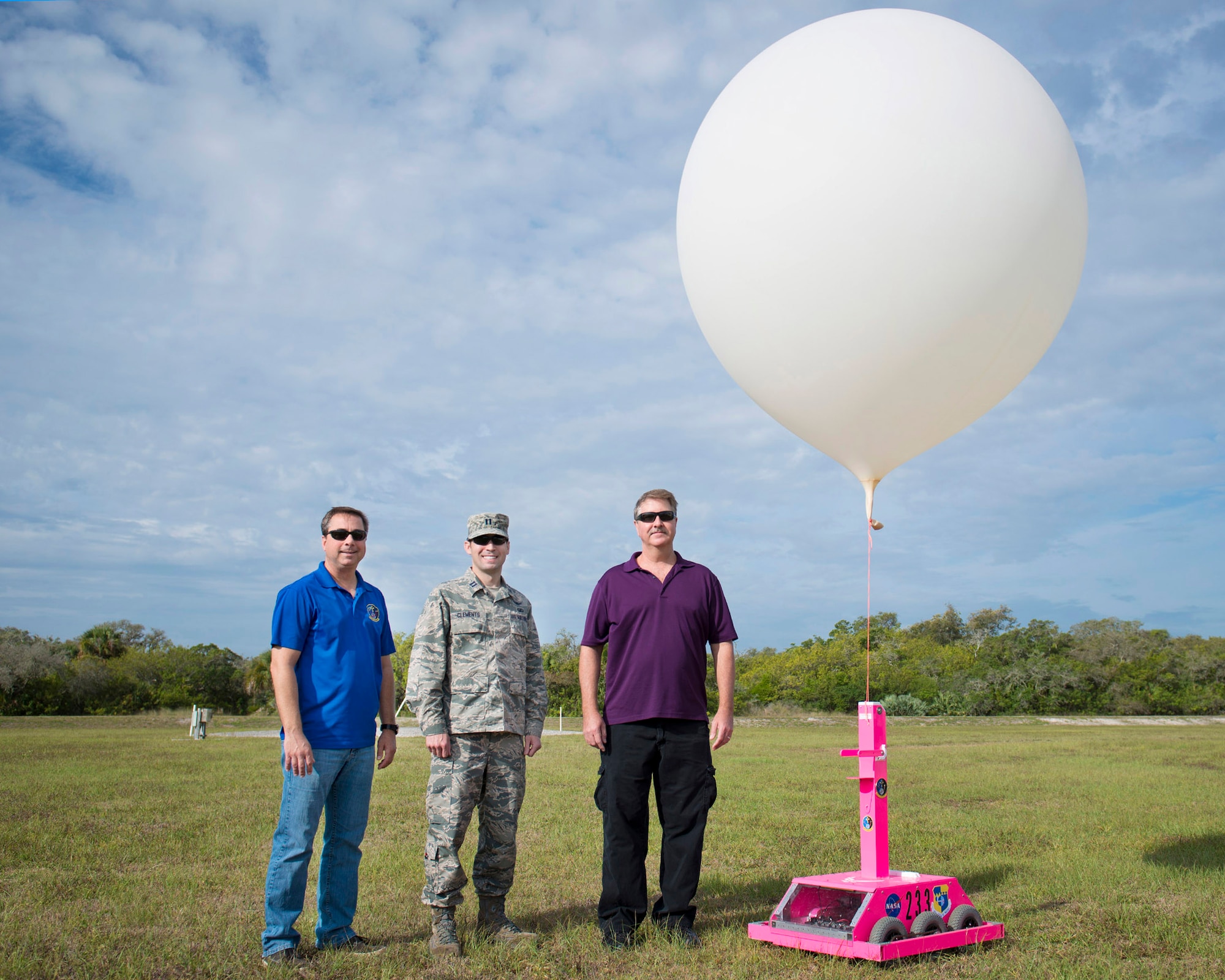 The winners of the 2015 Air Force Space Command Ivan A. Getting Innovation Award, left to right, Mike McAleenan, 45th Weather Squadron, Capt. Kyle Clements, 5th Space Launch Squadron, Andrew Bradley, NASA Kennedy Space Center, and Maj. Perry Sweat (not pictured), 45th Weather Squadron, stand with the WeatherBot April 22, 2016, at Cape Canaveral Air Force Station, Florida. (U.S. Air Force photo by Matthew Jurgens/Released)
