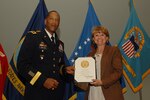 Kathleen Nolan, Customer Operations program and management analyst, receives a career service award certificate for 40 years of government service.  