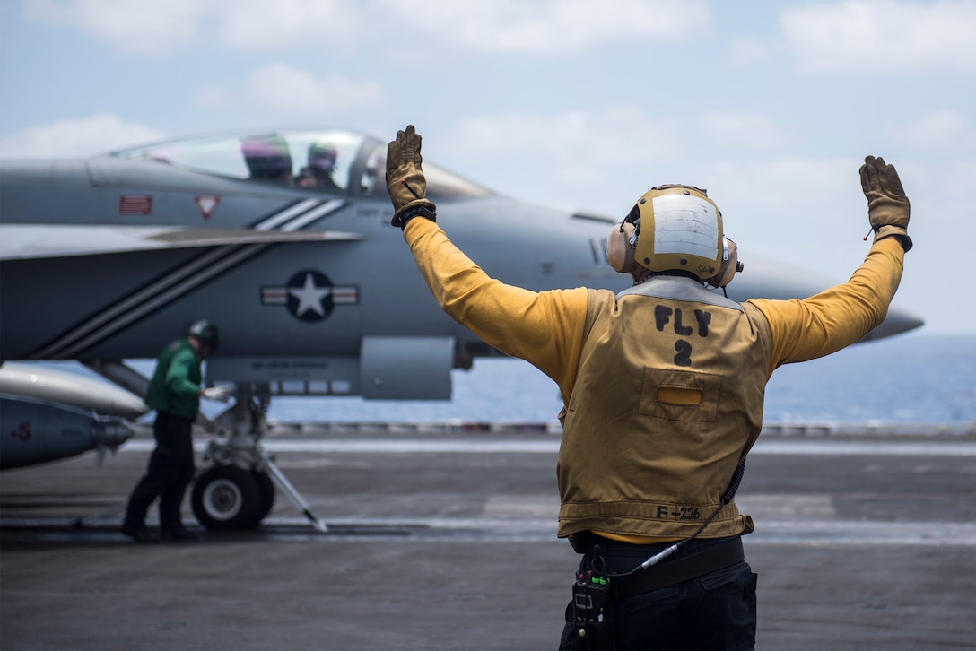 Navy Petty Officer 3rd Class Evan Bell directs an F/A-18E Super Hornet assigned to Strike Fighter Squadron 143 on the flight deck of the aircraft carrier USS Harry S. Truman on the Mediterranean Sea, June 8, 2016. The Harry S. Truman Carrier Strike Group is deployed in support of Operation Inherent Resolve, maritime security operations and theater security cooperation efforts in the U.S. 6th Fleet area of operations. Navy photo by Petty Officer 3rd Class Lindsay A. Preston