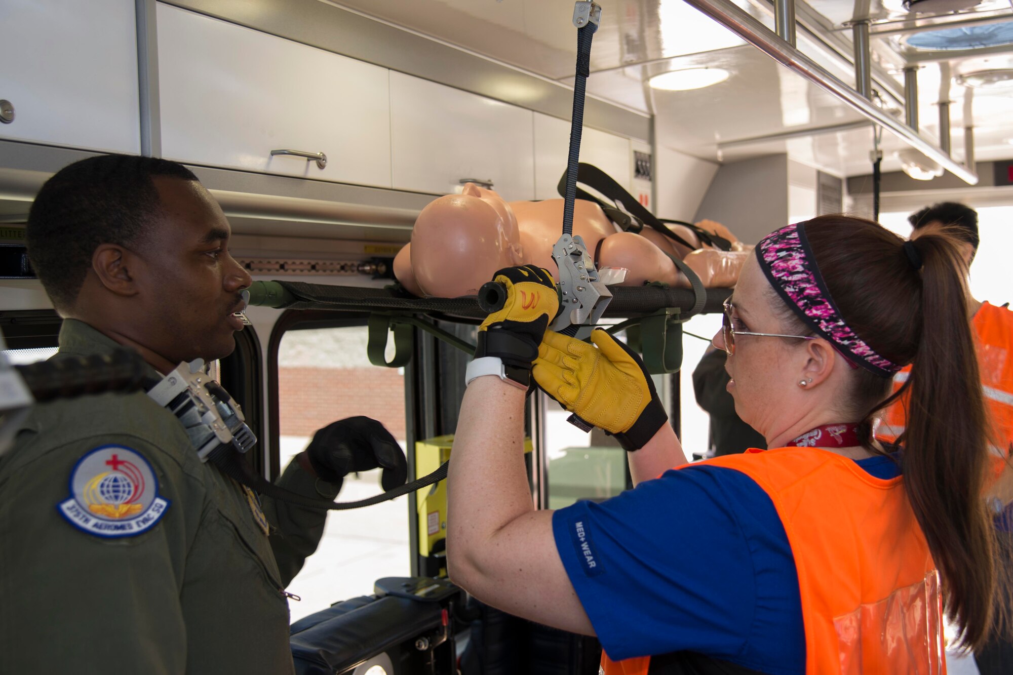 Staff Sgt. Irwin Jones, 375th AES, instructs a VA employee on the process of securing a litter into the mock aircraft. The joint training exercise was developed to prepare VA employees in the case of a disaster scenario. 