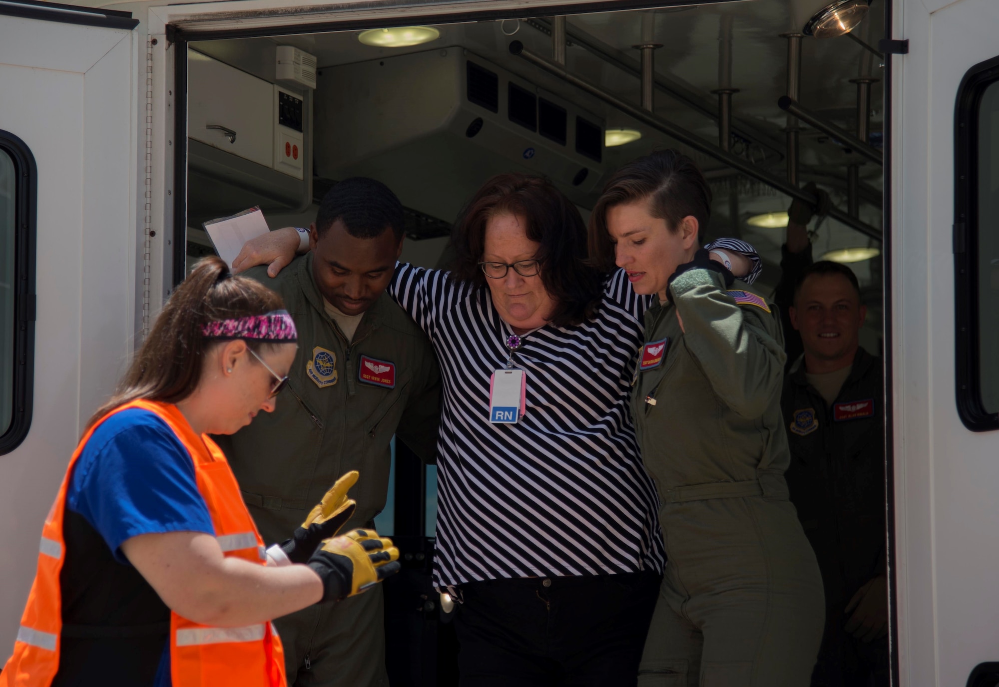 Jones and Staff Sgt. Darya Ermanova, 375th AES, demonstrate the proper transportation technique for an ambulatory patient aboard a crisis response evacuation vehicle. When transporting injured patients across unstable terrain, having an individual act as “spotter” to prevent further injury to the patient or responders is critical. (U.S. Air Force photo/Sean Clements)