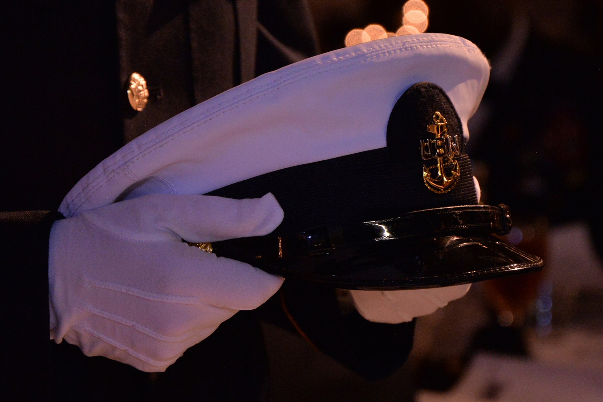 An Honor Guard member places a U.S. Navy hat on the POW/MIA “Missing Man” table during the 344th Military Intelligence Battalion Army Ball at the Fort Concho Stables in San Angelo, Texas, June 10, 2016.  The table is set in remembrance of service members who are prisoners of war or missing in action. (U.S. Air Force photo by Airman 1st Class Randall Moose/Released)