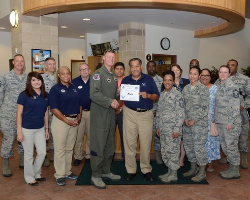 Jose Gamez, center, 47th Force Support Squadron recreation aid, accepts the “XLer of the Week” award from Col. Thomas Shank, left, 47th Flying Training Wing commander, and Chief Master Sgt. Erica Shipp, right, 47th Mission Support Group superintendent, here, June 8, 2016. The XLer is a weekly award chosen by wing leadership and is presented to those who consistently make outstanding contributions to their unit and Laughlin. (U.S. Air Force photo/Airman 1st Class Brandon May)