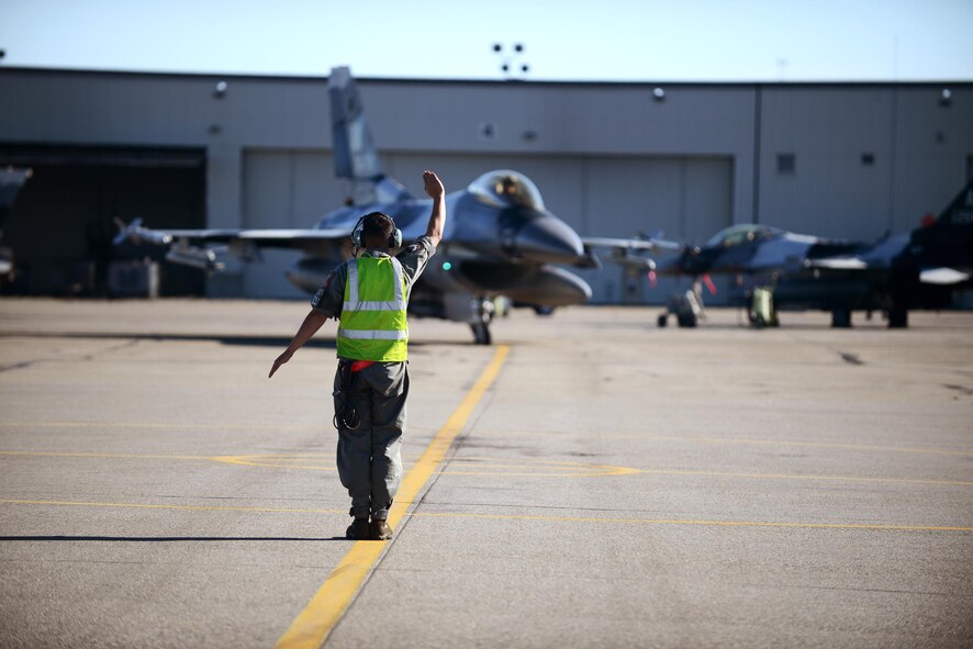 U.S. Air Force Staff Sgt. Nathaniel Moore, an F-16 Fighting Falcon dedicated crew chief with the18th Aircraft Maintenance Unit, marshals an F-16 for end-of-ramp operations during RED FLAG-Alaska 16-2, on Eielson Air Force Base, Alaska, June 15, 2016. (U.S. Air Force photo by Tech. Sgt. Steven R. Doty)