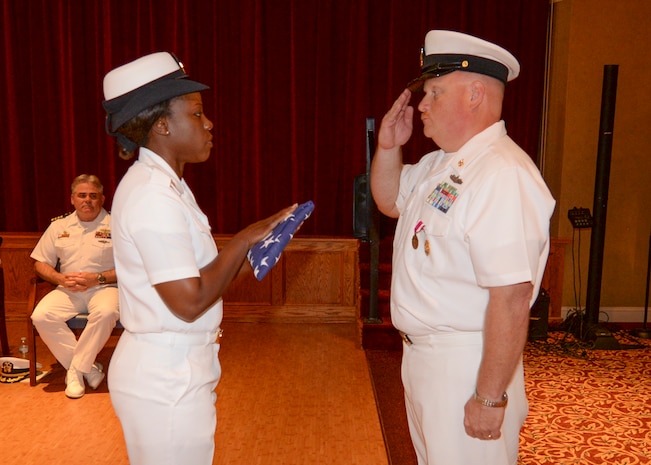 Command Master Chief Joseph Gardner receives a flag as part of his retirement ceremony, June 10, 2016, at the Joint Base Charleston – WS, Red Bank Club. Gardner served for more than 28 years in the United States Navy. (U.S. Navy Photo by Mass Communication Specialist Sean M. Stafford/Released)