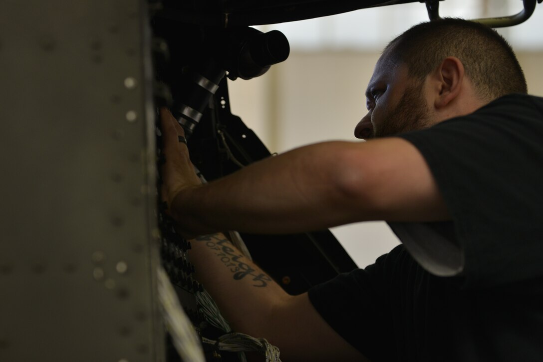 Barney Crews, U.S. Falcon Inc. avionics technician, installs a new power distribution panel into an AH-64D Apache trainer that is being updated to an AH-64E at Ft. Eusits, Va., June 13, 2016. The Apache trainers are being updated for the 128th Aviation Brigade’s Advanced Individual Training programs. (U.S. Air Force photo by Staff Sgt. Natasha Stannard/Released)  