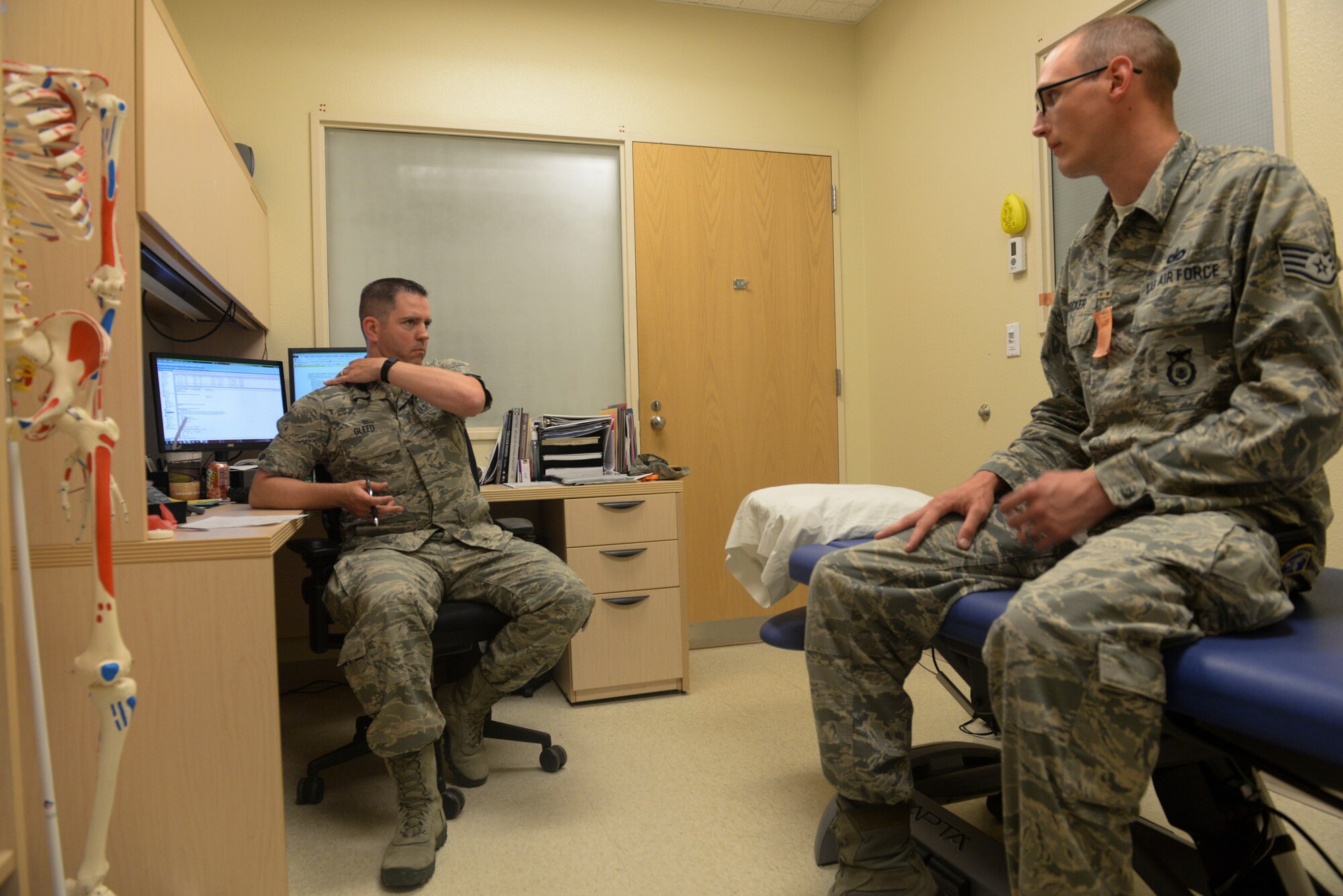 Capt. Justin Gleed, a physical therapist assigned to the 5th Medical Operations Squadron at Minot Air Force Base, N.D., consults with a patient June 10, 2016. The physical therapy clinic uses their knowledge of the anatomy and physiology of the human body to help correct injuries or impairments so Airmen can continue their job. (U.S. Air Force photo/Airman 1st Class Jessica Weissman)