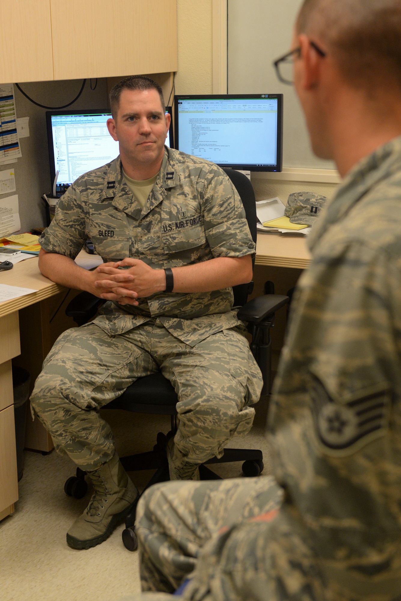 Capt. Justin Gleed, a physical therapist assigned to the 5th Medical Operations Squadron at Minot Air Force Base, N.D., consults with a patient June 10, 2016. U.S Air Force physical therapists use guided exercises, hands-on treatment and pain management modalities to ensure patients get the treatment necessary to heal. (U.S. Air Force photo/Airman 1st Class Jessica Weissman)
