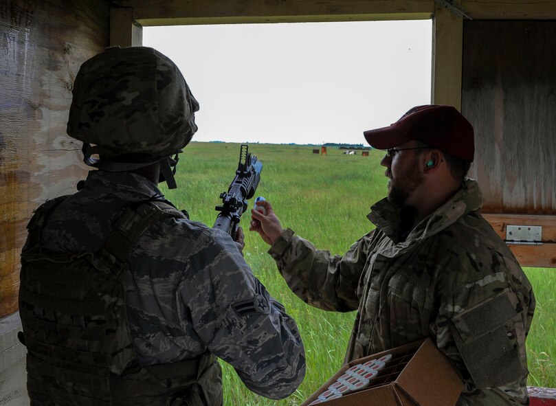 Jeremy Smith, Combat Arms instructor, loads an M-203 grenade launcher cartridge into a weapon during annual firing for defenders at Minot Air Force Base, N.D., June 15, 2016. Prior to firing, the defenders learned how to break down the M-203 and clean it. To carry the weapon, defenders must qualify annually. (U.S. Air Force photo/Senior Airman Kristoffer Kaubisch)