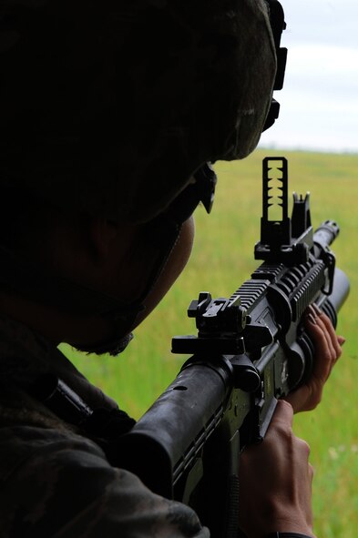 A defender from Team Minot looks down the sight of her M-203 grenade launcher at Minot Air Force Base, N.D., June 15, 2016. Prior to firing, the defenders learned how to break down the M-203 and clean it. To carry the weapon, defenders must qualify annually. (U.S. Air Force photo/Senior Airman Kristoffer Kaubisch)