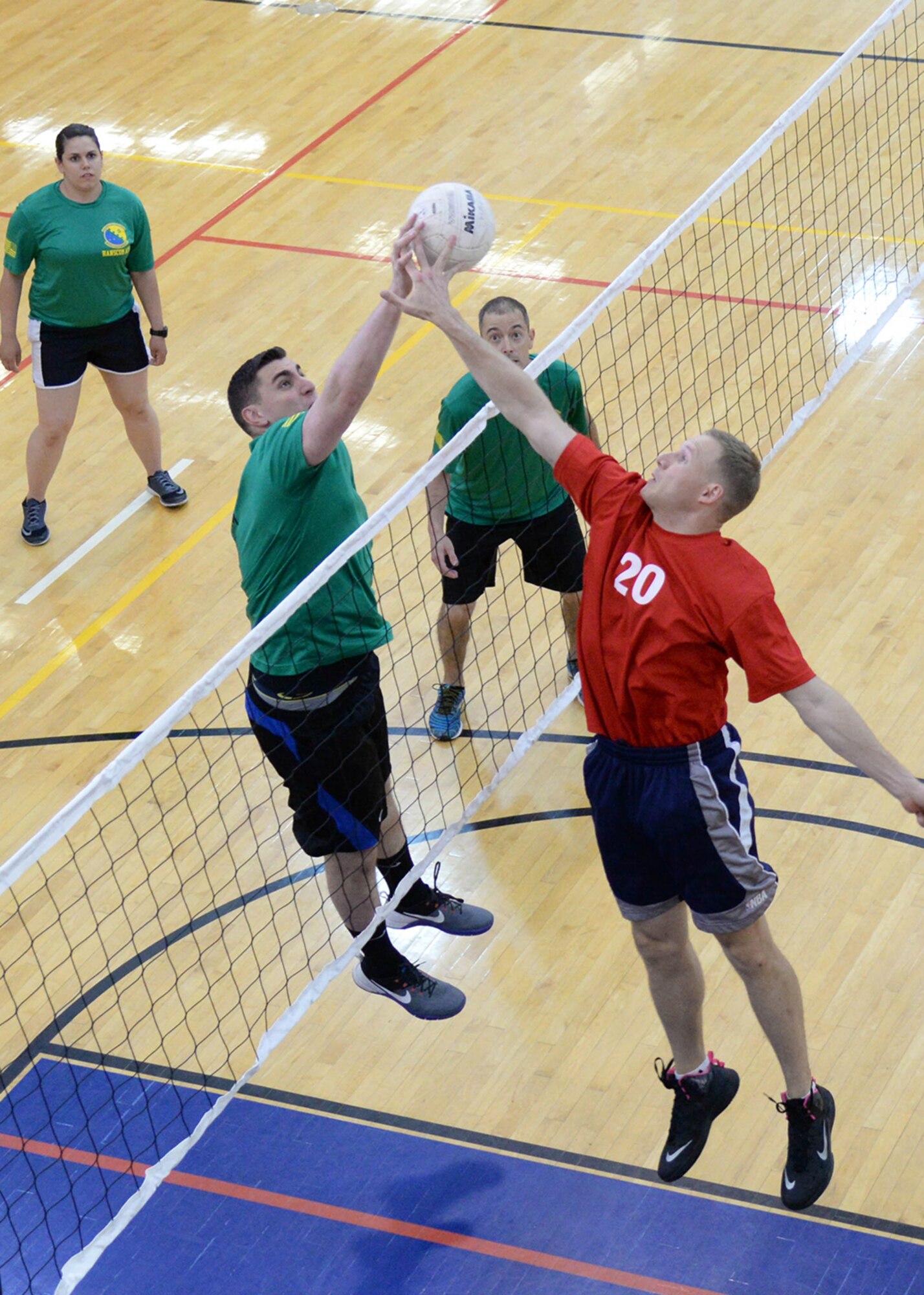 Capt. Matthew Cignoli, left, 66th Comptroller Squadron deputy budget officer, and Capt. Ryan Gustafson, 66th Medical Squadron staff dentist, compete for a ball at the net during a volleyball game at the Fitness and Sports Center June 14, while Senior Airman Jasmine Mendez, 66 CPTS customer service technician, and Airman 1st Class Kenneth McGuire, 66 CPTS account technician, look on. The volleyball game was part of the Hanscom Summer Games. An awards ceremony for the event is scheduled June 17 at 3 p.m. at the gazebo outside the base chapel for the entire Hanscom community. (U.S. Air Force photo by Linda LaBonte Britt)