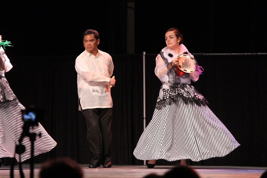 Armin M. Sayson, lead engineer for Headquarters Air Force Material Command, and a member of the traditional Filipino dance group called Pamana perform a traditional Philippine dance at the Wright-Patterson Club for a past International Fair. (Contributed photo/Armin M. Sayson)