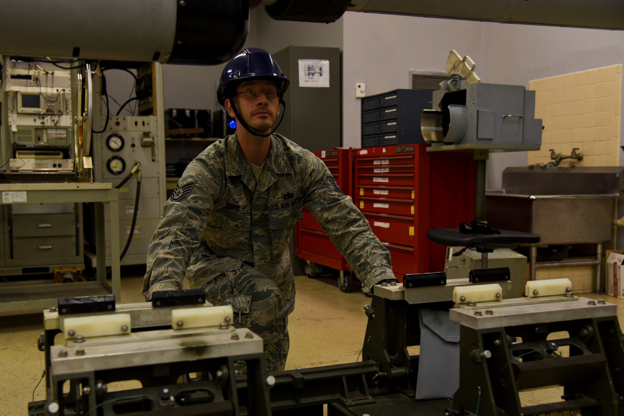 U.S. Air Force Tech. Sgt. William Rus, a 187th Electronic Warfare technician and production supervisor, Montgomery Regional Air National Guard Base, Ala., demonstrates how AN/ALQ-184 ECM pods are moved into the inspection area June 2, 2016, at the Montgomery Regional ANGB, Ala. The purpose of the pods are to jam radar or other detection systems. The pods keep the wing’s F-16 Fighting Falcon and pilots safe when flying into enemy territory. (U.S. Air National Guard photo by Airman 1st Class Hayden Johnson/Released)