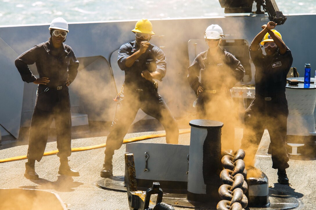 Two sailors signal to brake the port anchor chain aboard the amphibious transport dock ship USS Arlington in the Atlantic Ocean, June 14, 2016. Navy photo by Petty Officer 2nd Class Stevie Tate