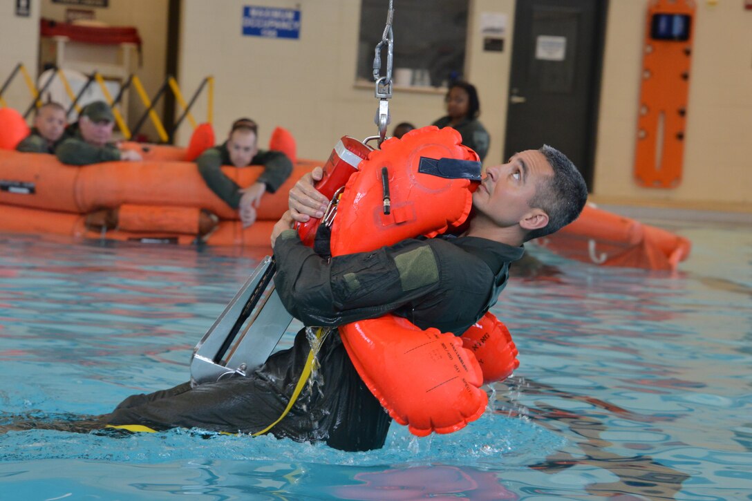 Air Force Master Sgt. Jorge Chavez demonstrates proper water extraction during water survival training at Hunter Army Airfield in Savannah, Ga., June 11, 2016. Airmen with the 165th Airlift Wing conducted the training to fulfill aircrew requirements. Air National Guard photo by Staff Sgt. Noel Velez